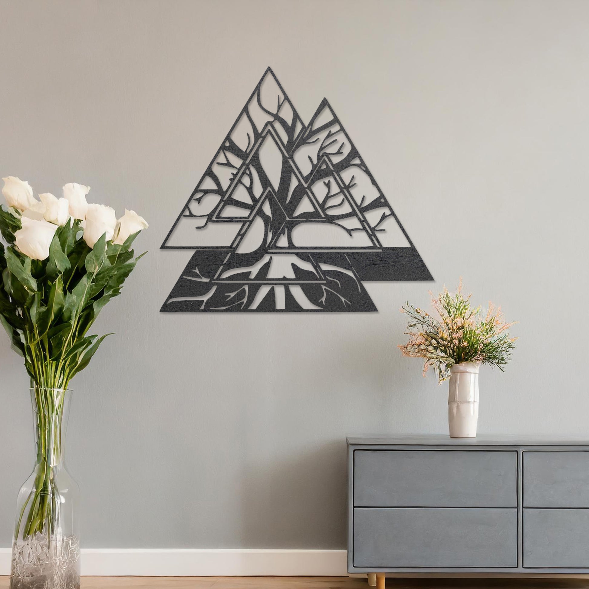 Wooden wall art design featuring a geometric triangular shape with intricate tree branches interwoven inside, placed on a neutral wall within modern room decor. The design combines nature and geometry for a contemporary, artistic expression.