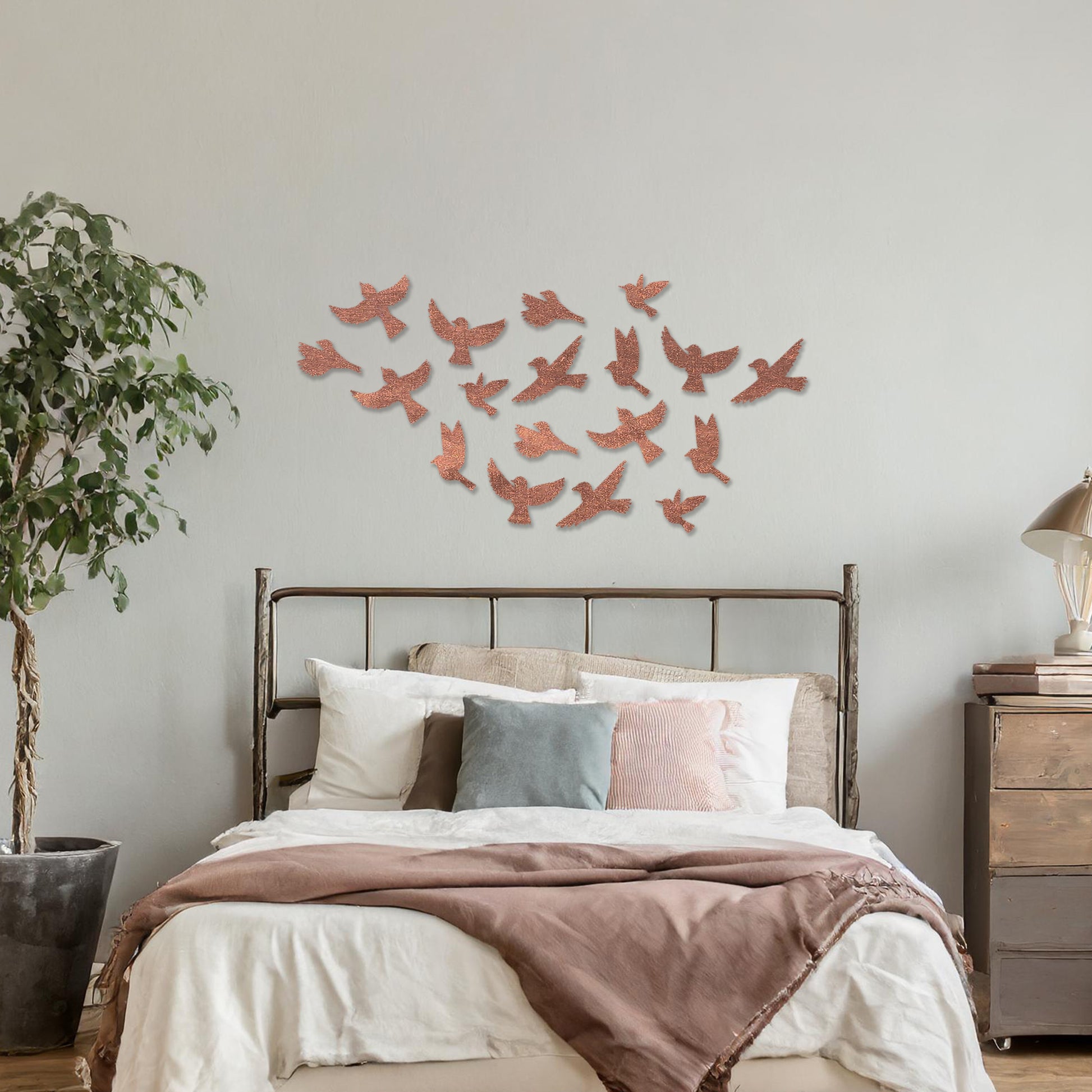Wooden wall art featuring a flock of birds in flight arranged in a scattered pattern, displayed on a neutral wall within modern room decor, highlighting its dynamic and nature-inspired craftsmanship.