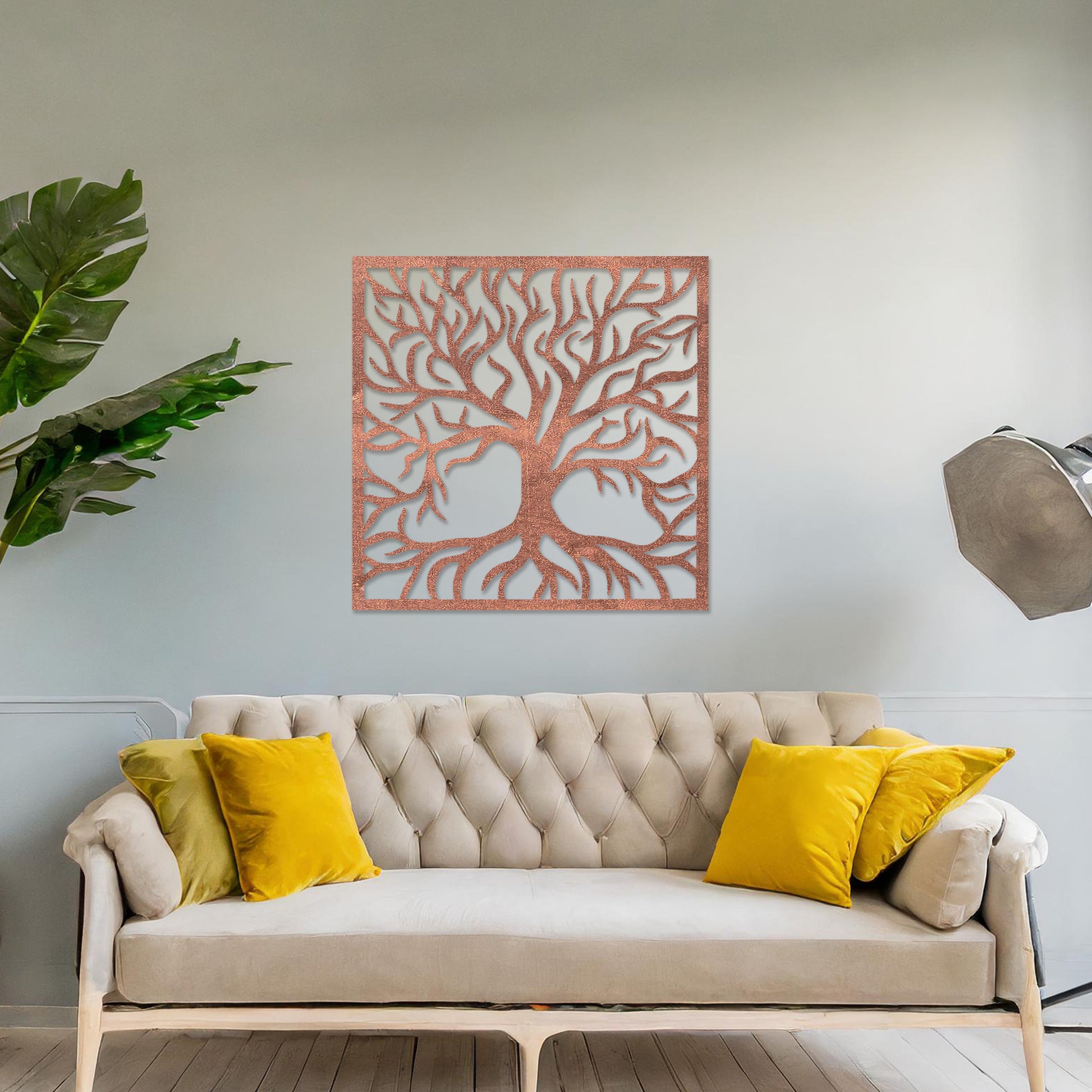 A square wall art piece depicting an intricate tree with branching limbs and visible roots. The artwork is displayed on a neutral wall in a modern room