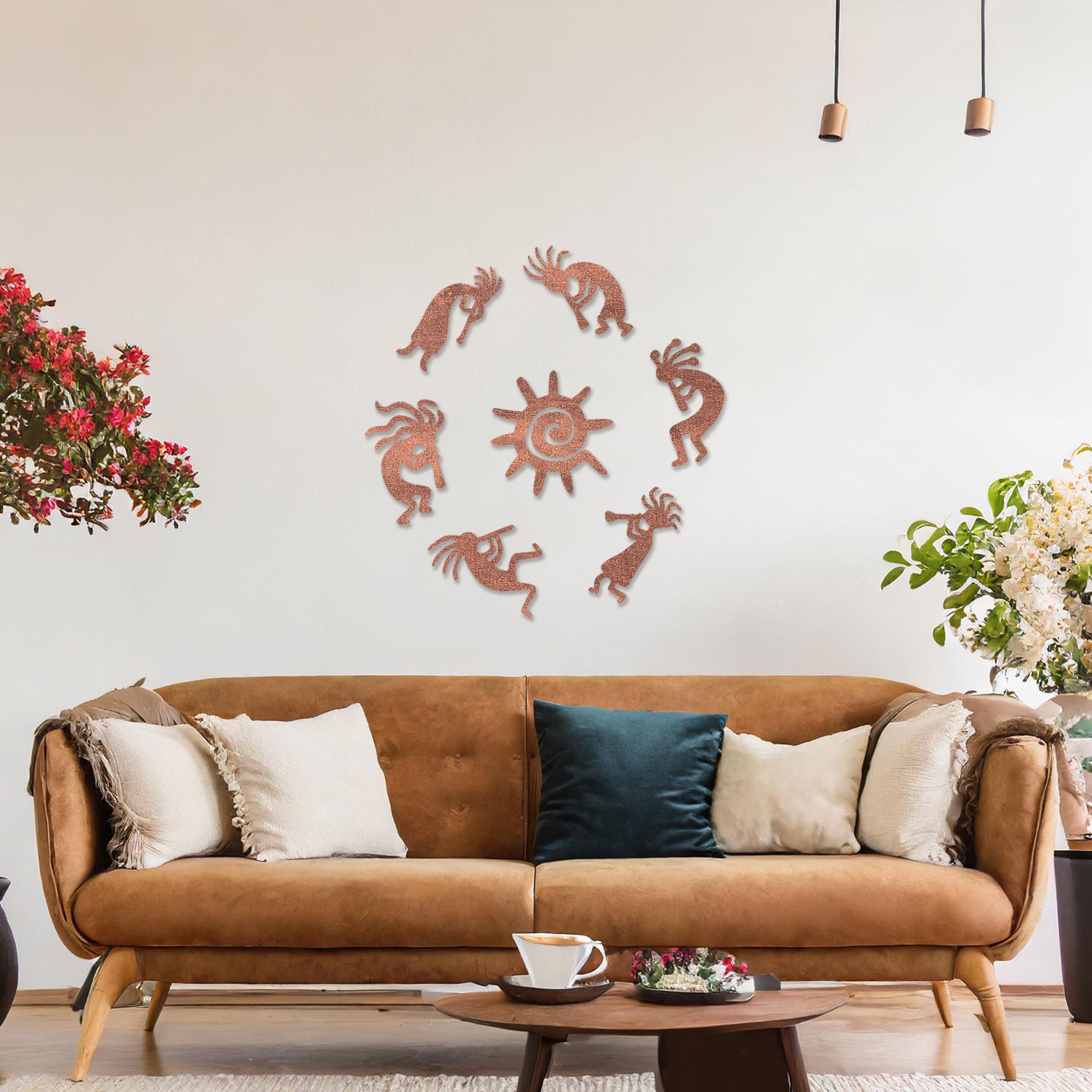 Wooden wall art featuring a circular arrangement of dancing figures surrounding a central sun design. The artwork is displayed on a neutral wall within modern room decor, highlighting its tribal and artistic charm.