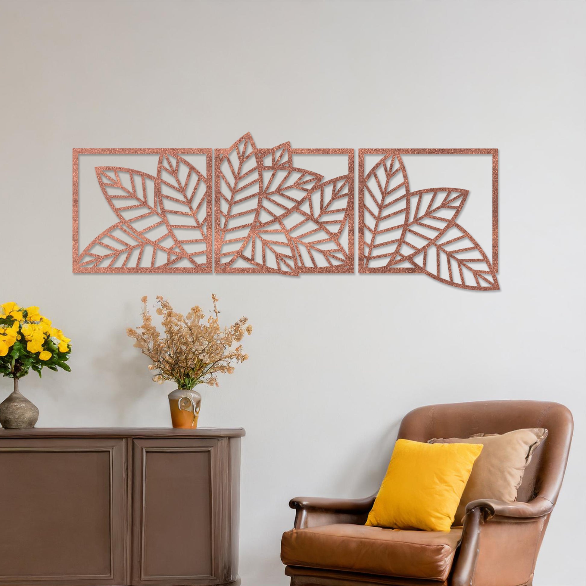 Wooden wall art featuring a three-panel design of overlapping leaf patterns with intricate cut-outs. The artwork is displayed on a neutral wall within modern room decor, highlighting its natural and elegant design.