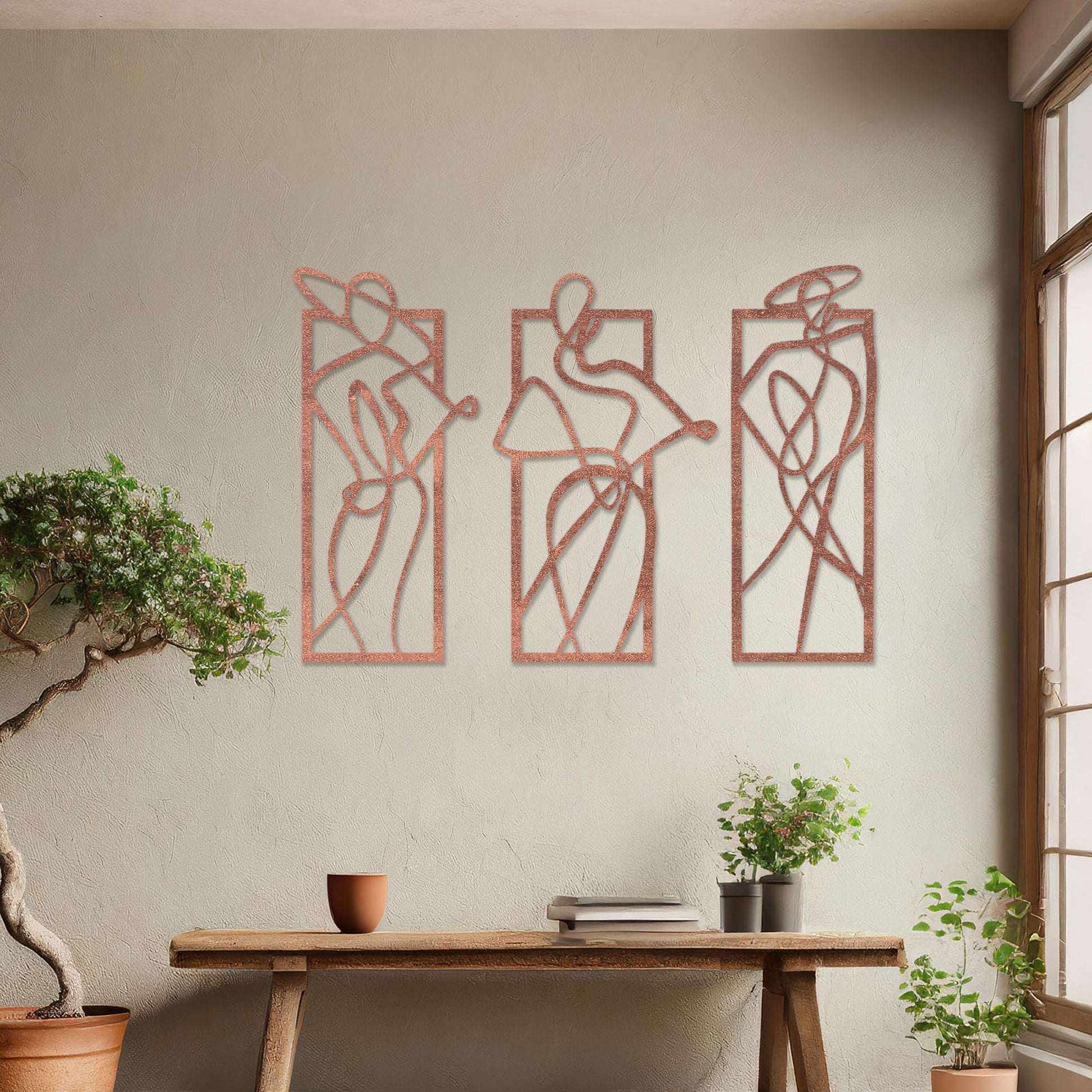 Wooden wall art design featuring three abstract figures in flowing lines, each in its own rectangular frame, placed on a neutral wall with modern room decor. The design evokes movement and elegance through minimalistic, artistic shapes.