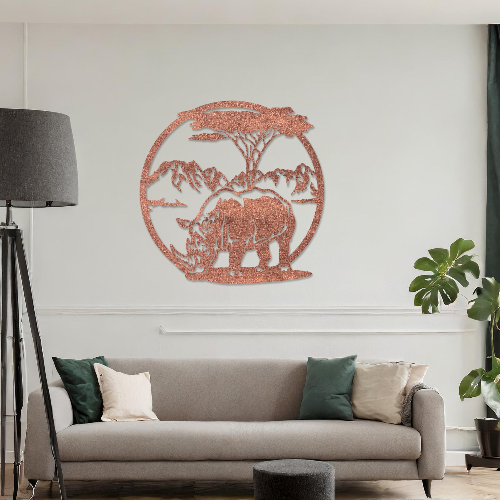 Wooden wall art design featuring a rhinoceros beneath a tree with a mountain backdrop, framed in a circular shape, placed on a neutral wall within modern room decor. The design captures the majesty of wildlife in a serene landscape.