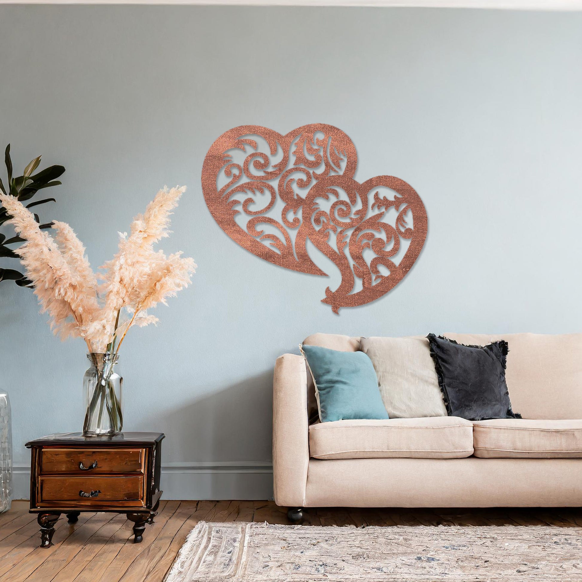 Wooden wall art design featuring two interlocking hearts with intricate swirling patterns, placed on a neutral wall within modern room decor. The design combines elegance and romance with its flowing shapes and fine details.