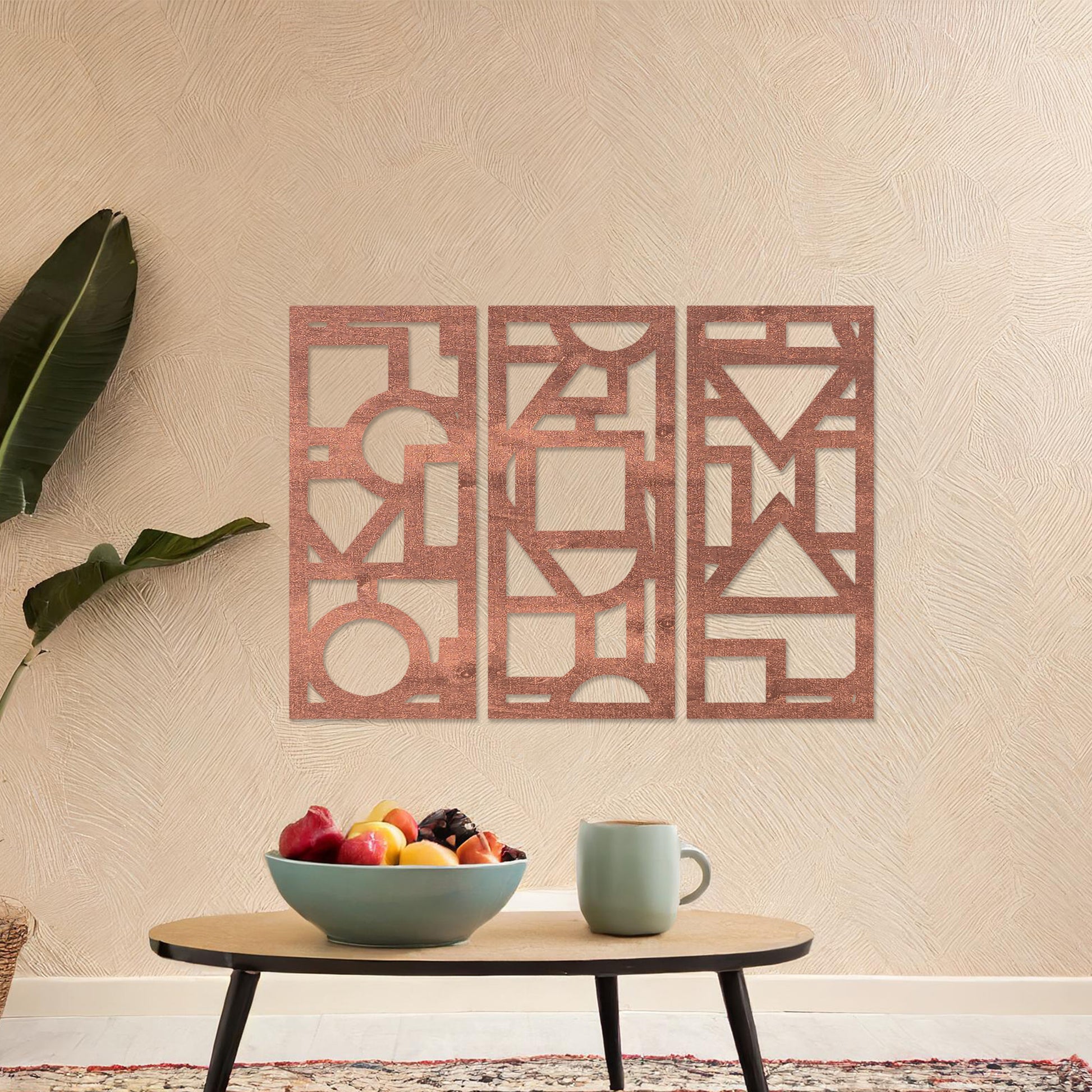 This image features a vibrant, modern triptych wall art design made of geometric shapes and patterns. The bold black designs contrast against a light green wall, complementing the stylish sofa below. 