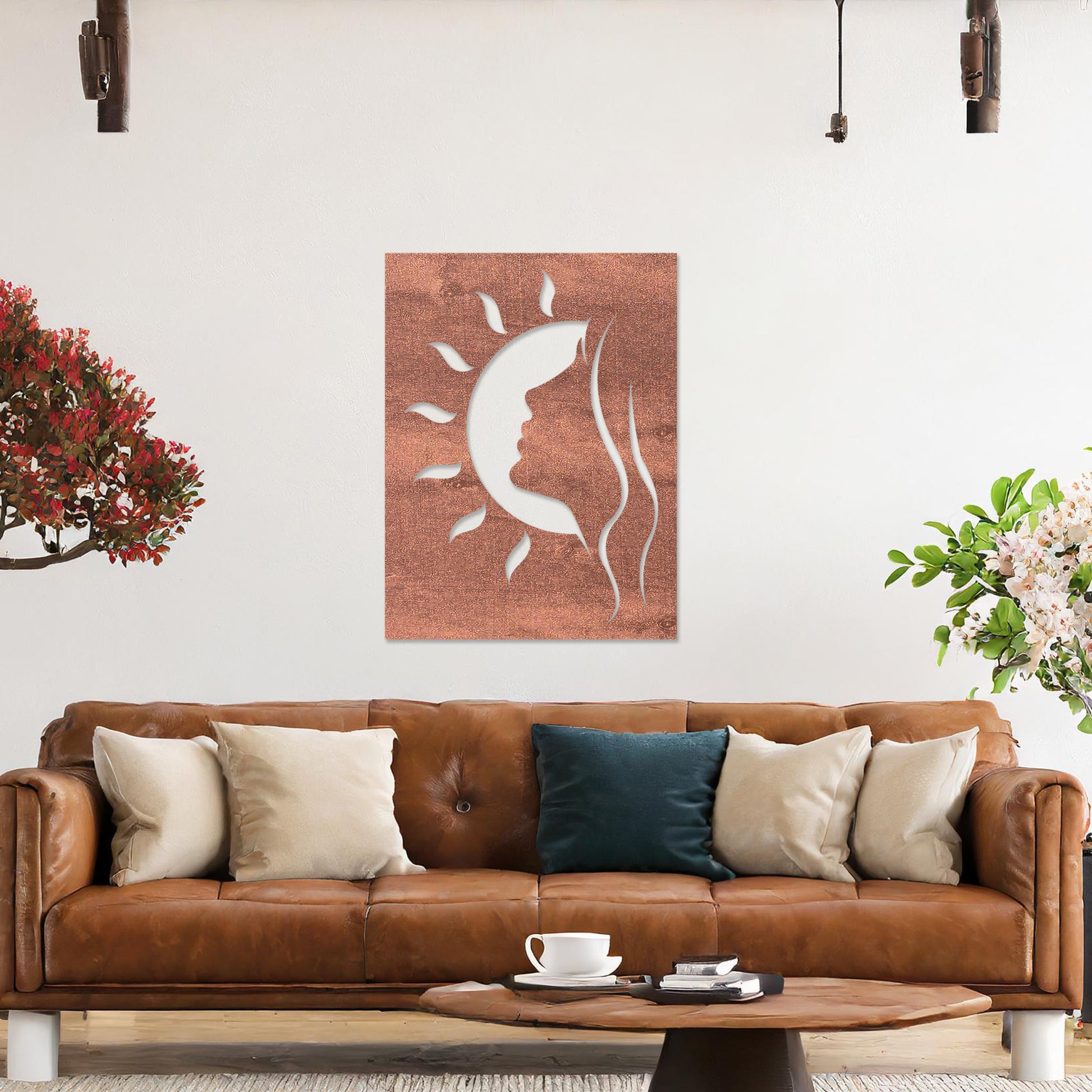 A rectangular wall art piece featuring a silhouette of a face intertwined with a crescent moon and radiating sun rays. The artwork is displayed on a neutral wall in a modern living room