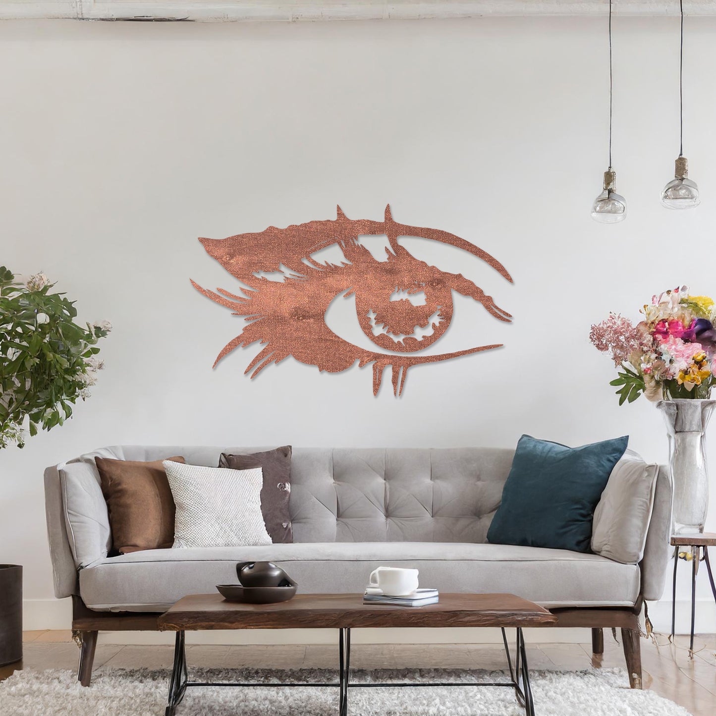 Wooden wall art featuring a stylised eye design with intricate detailing of lashes and bold lines. The artwork is displayed on a neutral wall within modern room decor, emphasising its artistic and striking pattern.