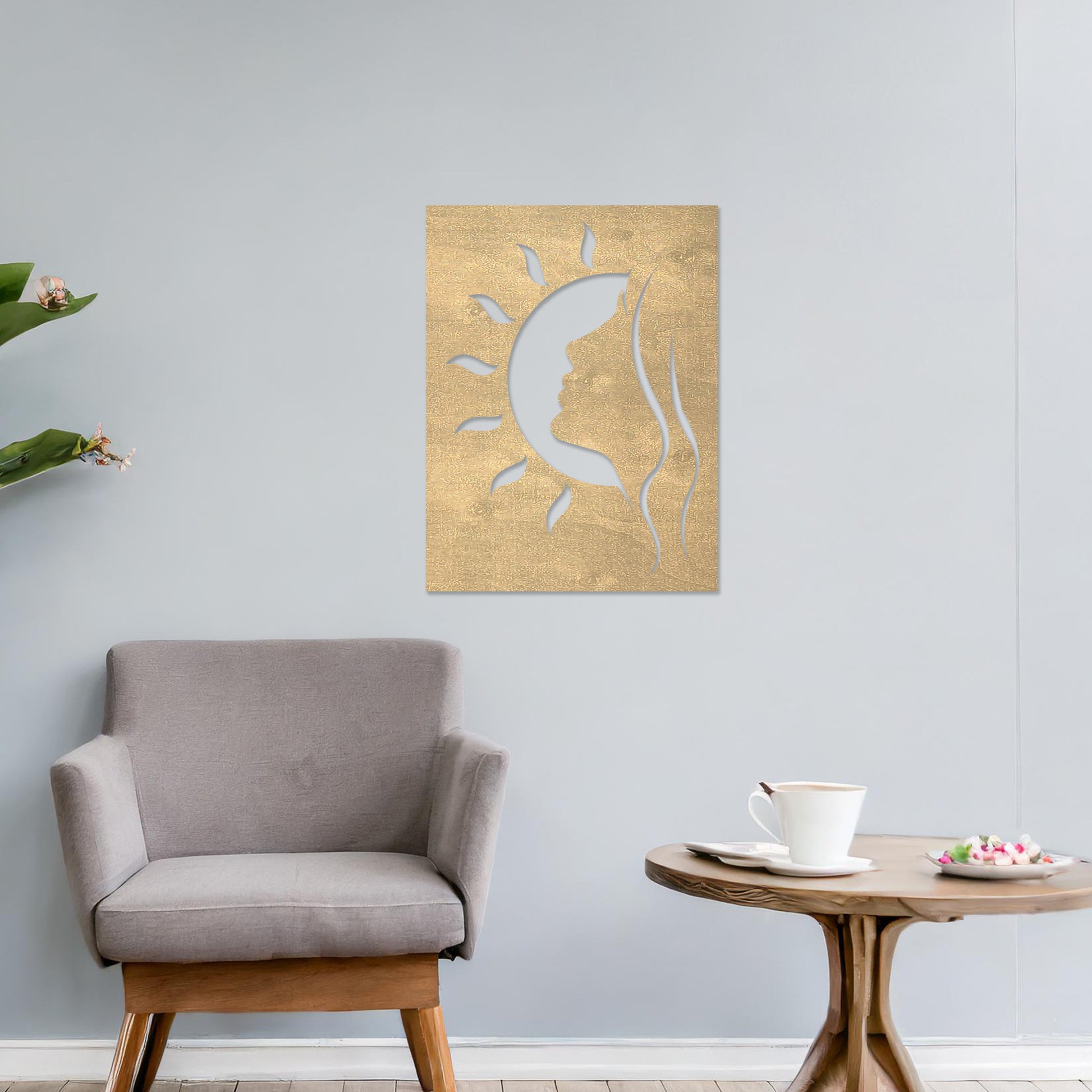A rectangular wall art piece featuring a silhouette of a face intertwined with a crescent moon and radiating sun rays. The artwork is displayed on a neutral wall in a modern living room