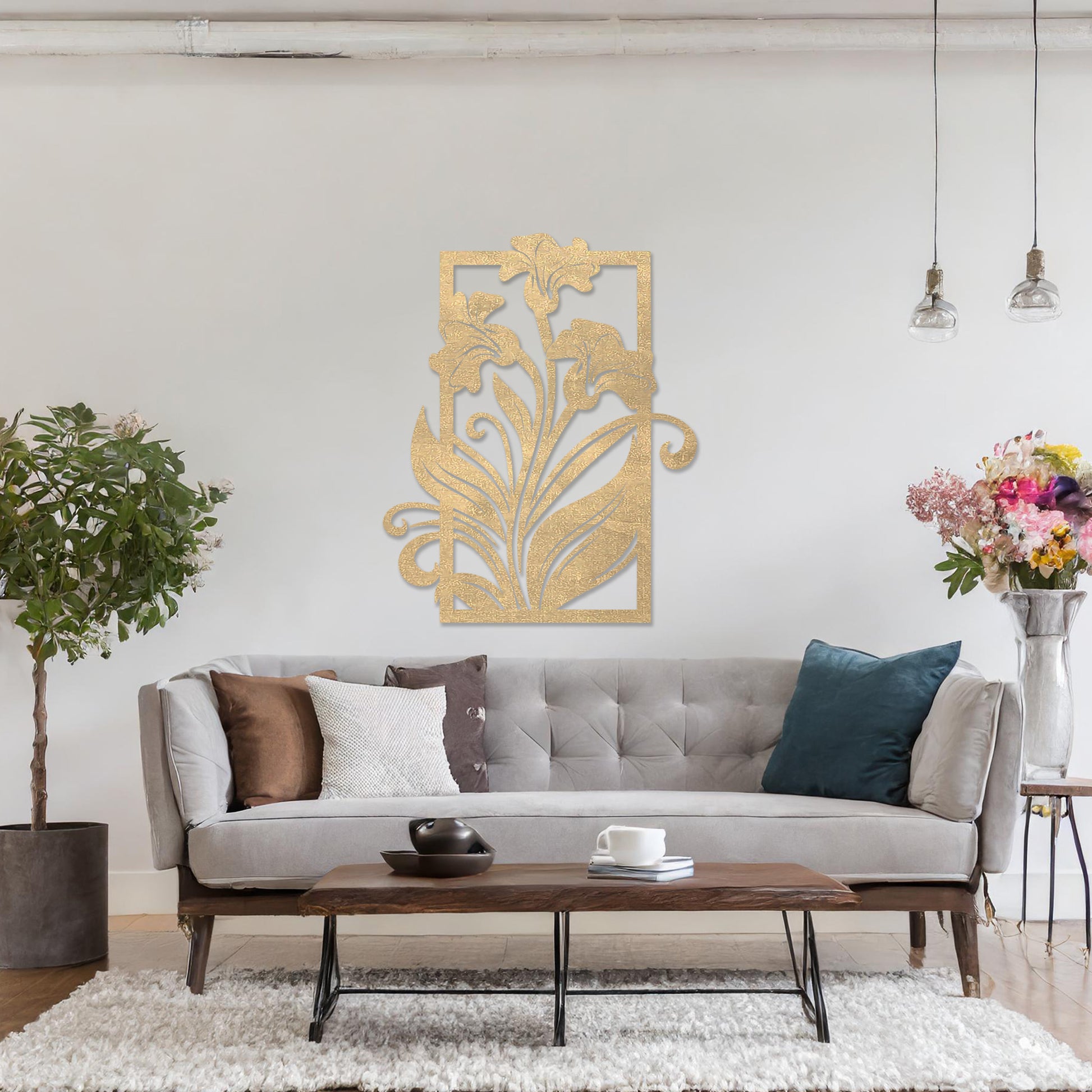 Wall art featuring an elegant floral design with three blooming lilies and flowing leaves enclosed in a rectangular frame. The piece is displayed on a neutral wall within modern room decor, adding a graceful and artistic touch to the setting.