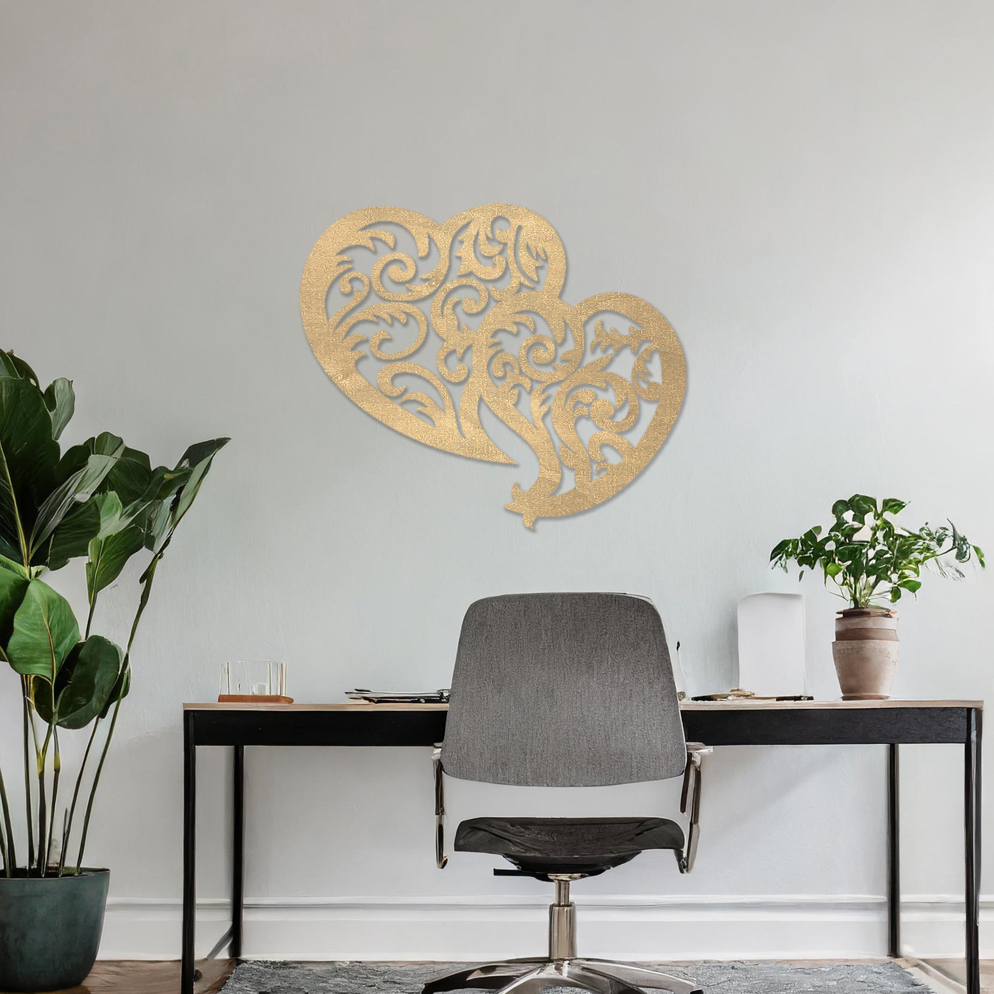 Wooden wall art design featuring two interlocking hearts with intricate swirling patterns, placed on a neutral wall within modern room decor. The design combines elegance and romance with its flowing shapes and fine details.