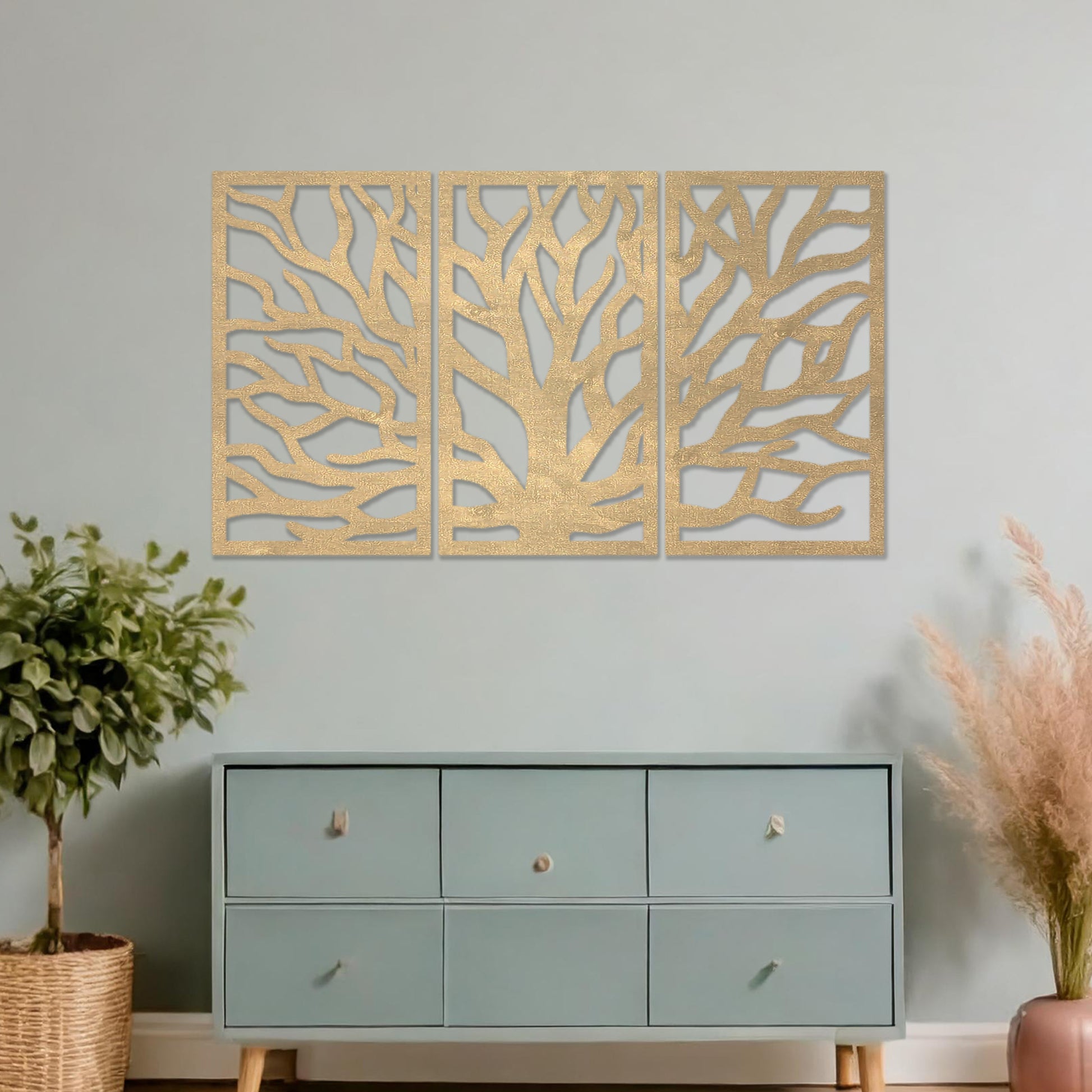 Wooden wall art consisting of three panels featuring an abstract tree branch design, displayed on a neutral wall within modern room decor, emphasising its artistic and contemporary appeal.
