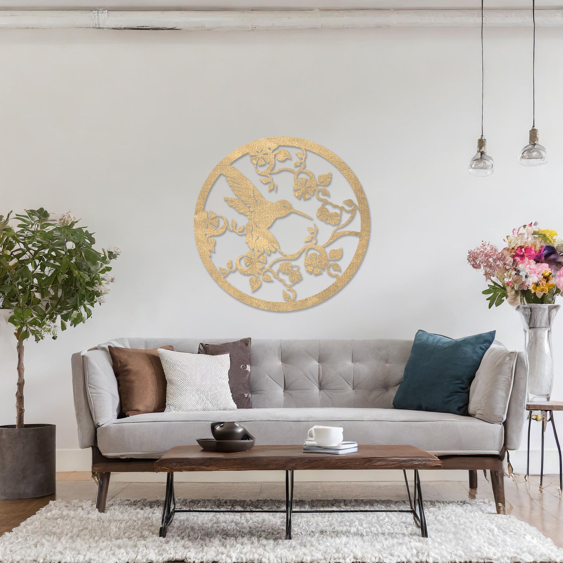 Wooden wall art design featuring a hummingbird amidst flowers and vines, framed in a circular shape, placed on a neutral wall within modern room decor. The design captures the elegance of nature with intricate details.