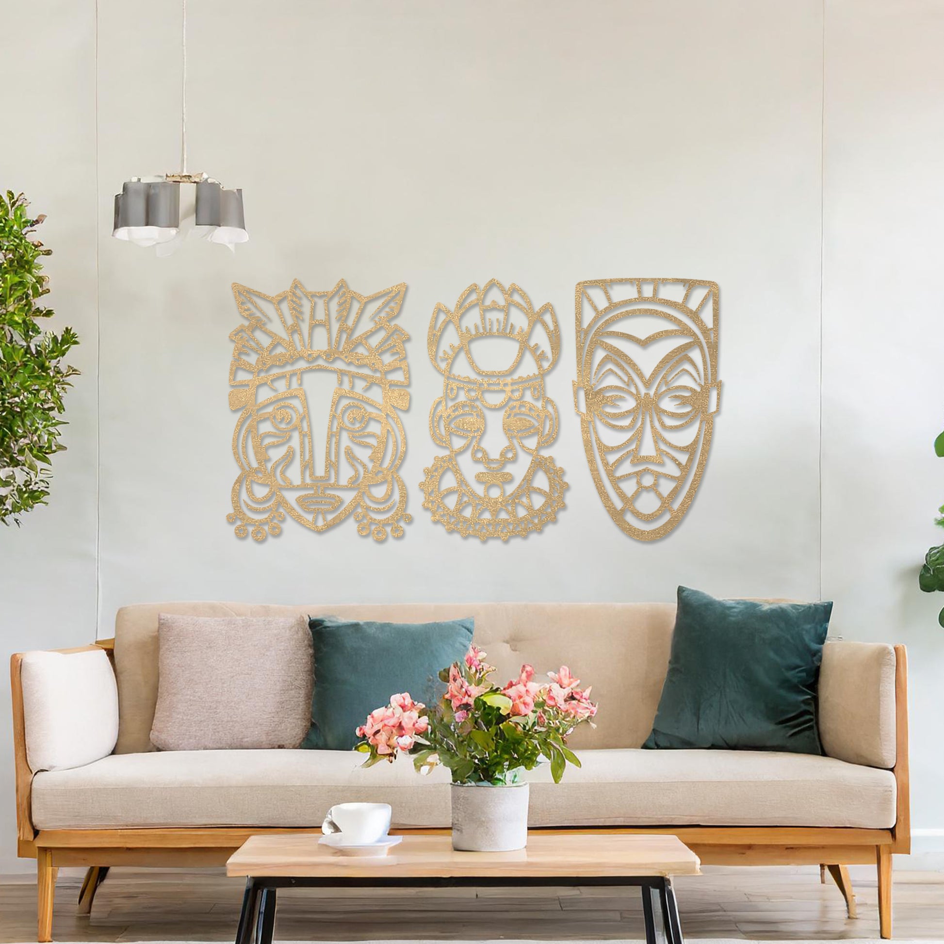 This is a wall art design featuring three tribal masks with intricate details, displayed on a neutral wall. The masks' features and patterns create an eye-catching, cultural focal point, enhancing the modern room's decor.