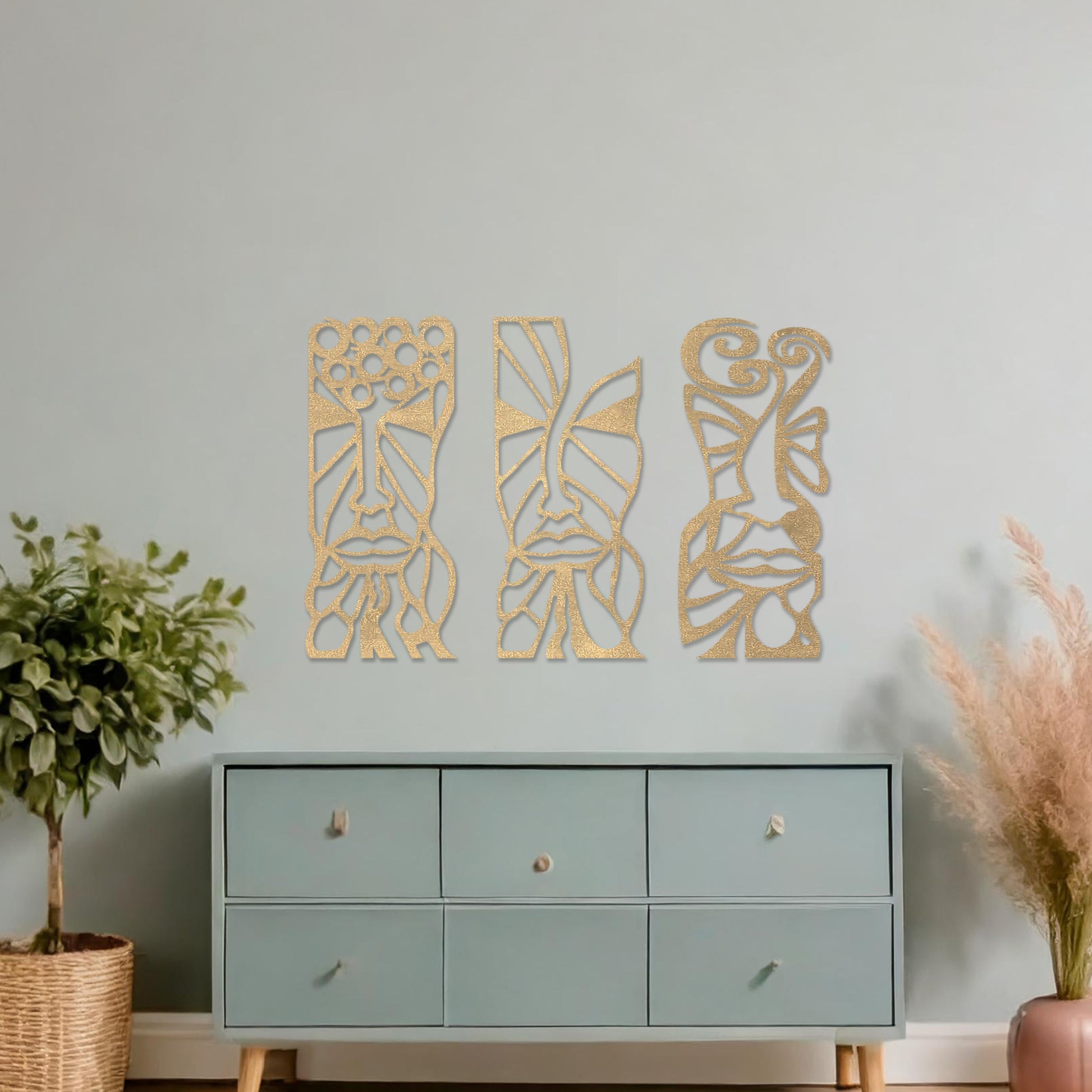Wooden wall art set featuring three abstract face designs with intricate geometric and flowing patterns, displayed on a neutral wall within modern room decor, highlighting their artistic and contemporary appeal.
