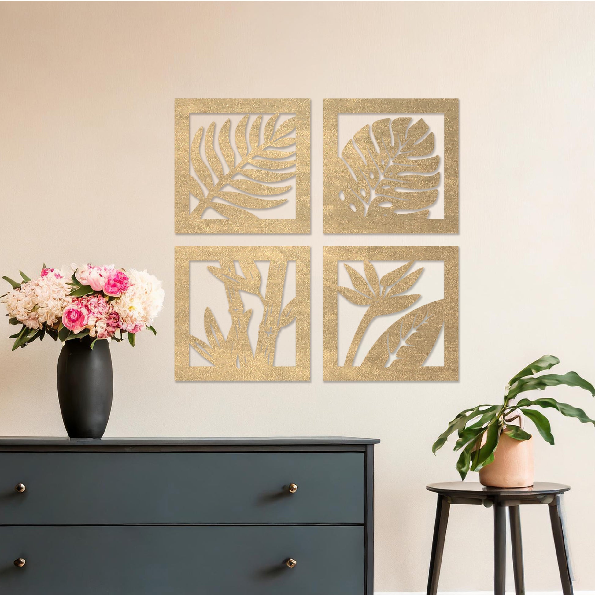 Wooden wall art design featuring four square panels with different plant leaf motifs, placed on a neutral wall within modern room decor. The design highlights nature's variety with intricate leaf patterns in a minimalist style.