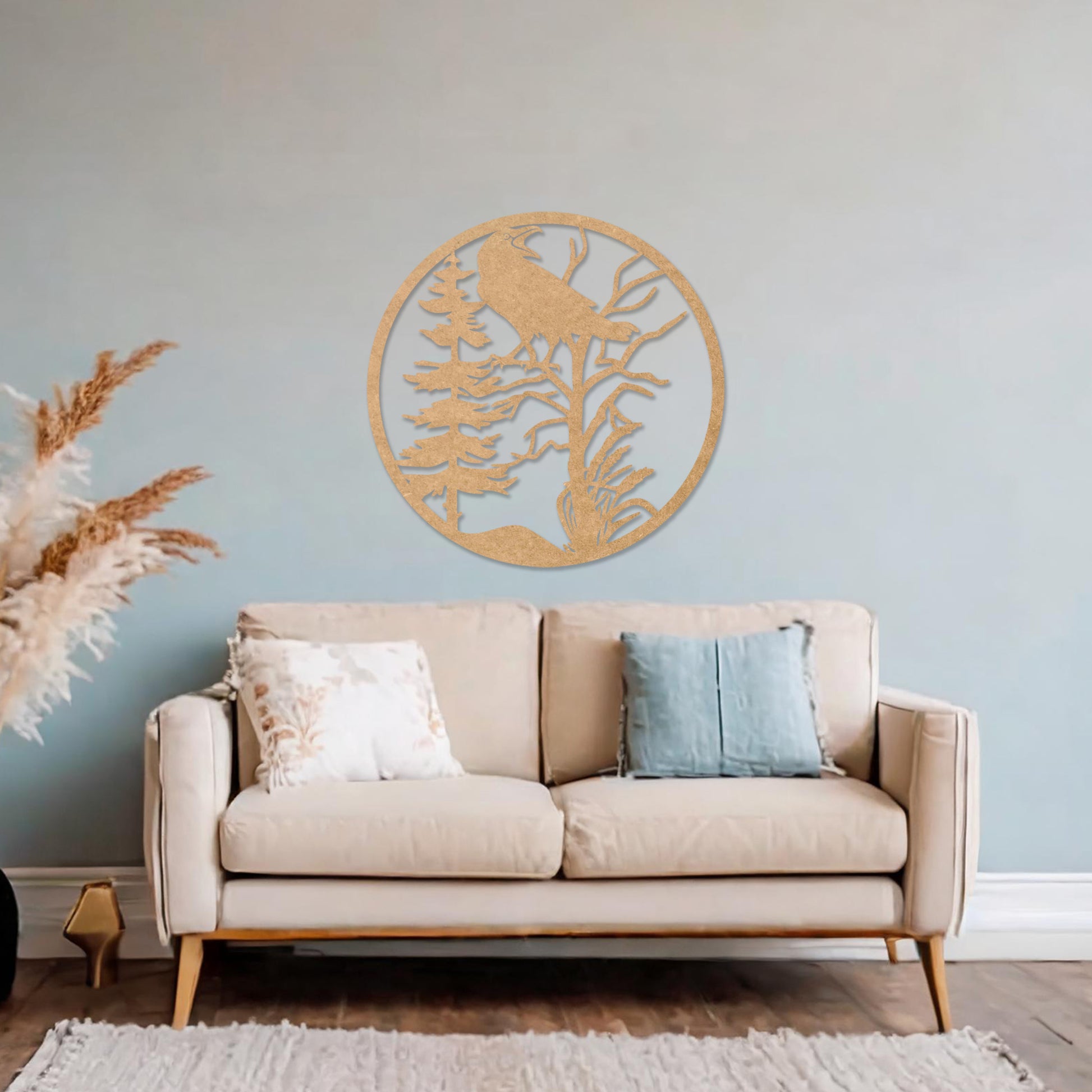 Wooden wall art featuring a circular design with a silhouette of a bird perched on a tree surrounded by natural elements. The artwork is displayed on a neutral wall within modern room decor, highlighting its rustic and nature-inspired design.