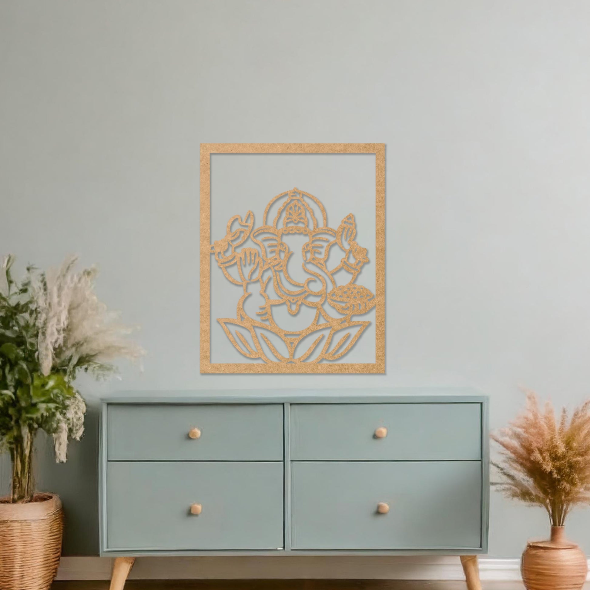 Wooden wall art featuring a framed design of Lord Ganesha sitting on a lotus flower with intricate details. The artwork is displayed on a neutral wall within modern room decor, highlighting its cultural and artistic elegance.