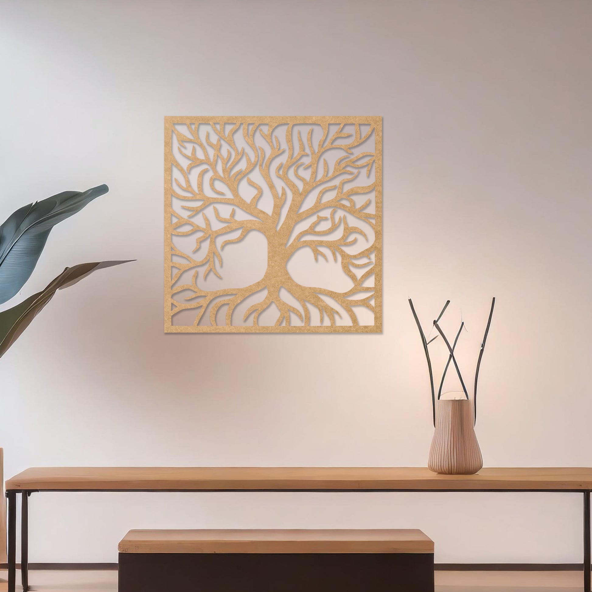 A square wall art piece depicting an intricate tree with branching limbs and visible roots. The artwork is displayed on a neutral wall in a modern room