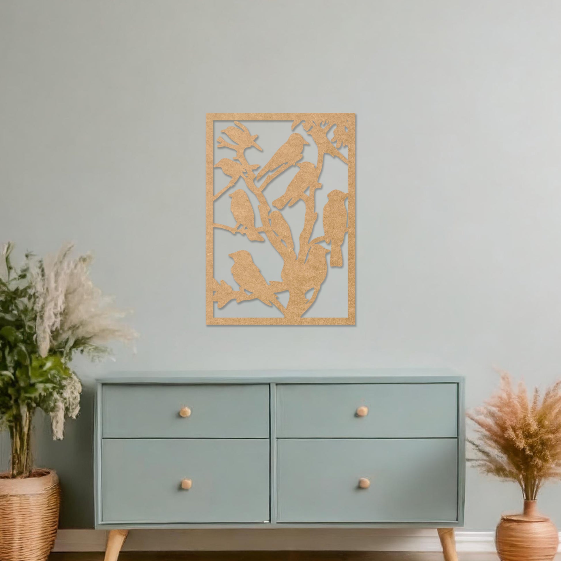 Wooden wall art featuring a detailed design of birds perched on branches. The artwork is displayed on a neutral wall within modern room decor, highlighting the intricate natural pattern.