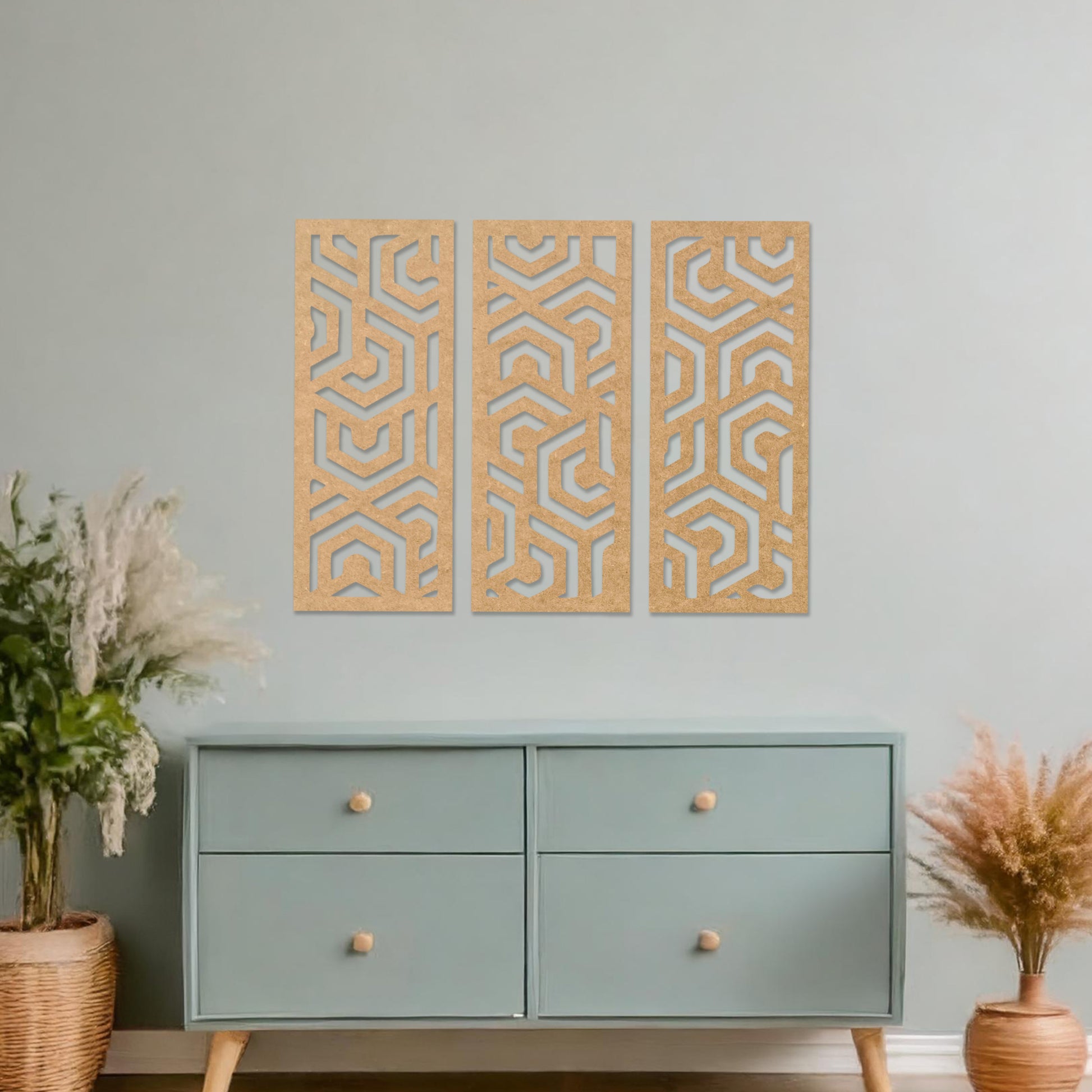 Wooden wall art featuring a three-panel design with intricate geometric patterns. The artwork is displayed on a neutral wall within modern room decor, highlighting its bold and symmetrical design.