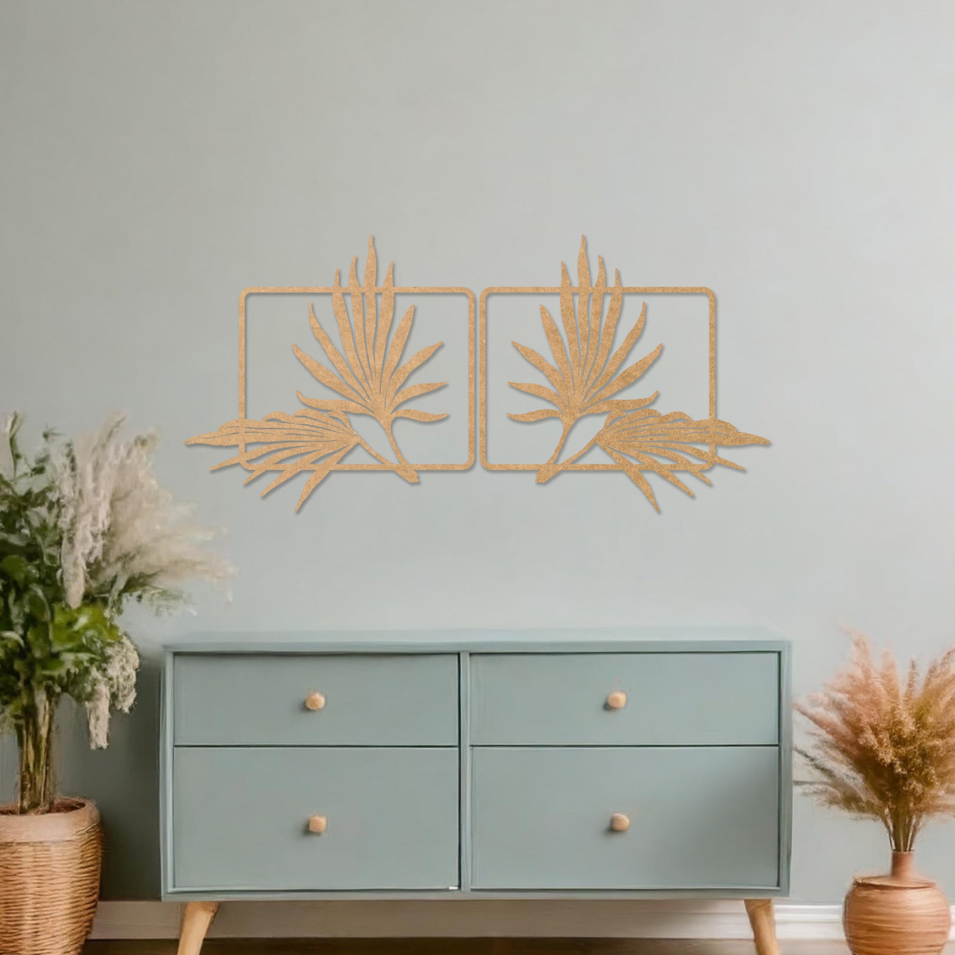 Wooden wall art featuring two symmetrical palm leaf designs within rectangular frames. The artwork is placed on a neutral wall in modern room decor, showcasing its elegant natural motif.