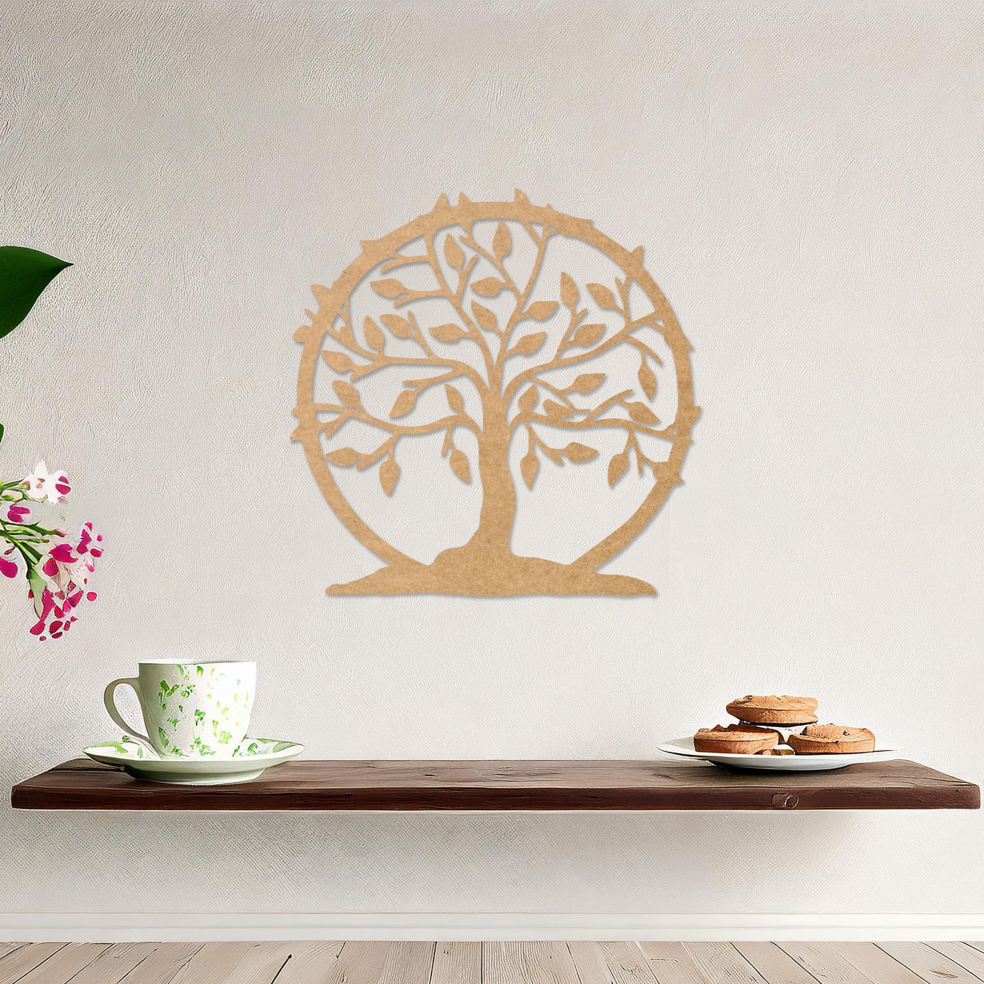 Wooden wall art featuring a circular tree design with branches, leaves, and a border of thorns. The artwork is displayed on a neutral wall within modern room decor, emphasising its natural and symbolic charm.
