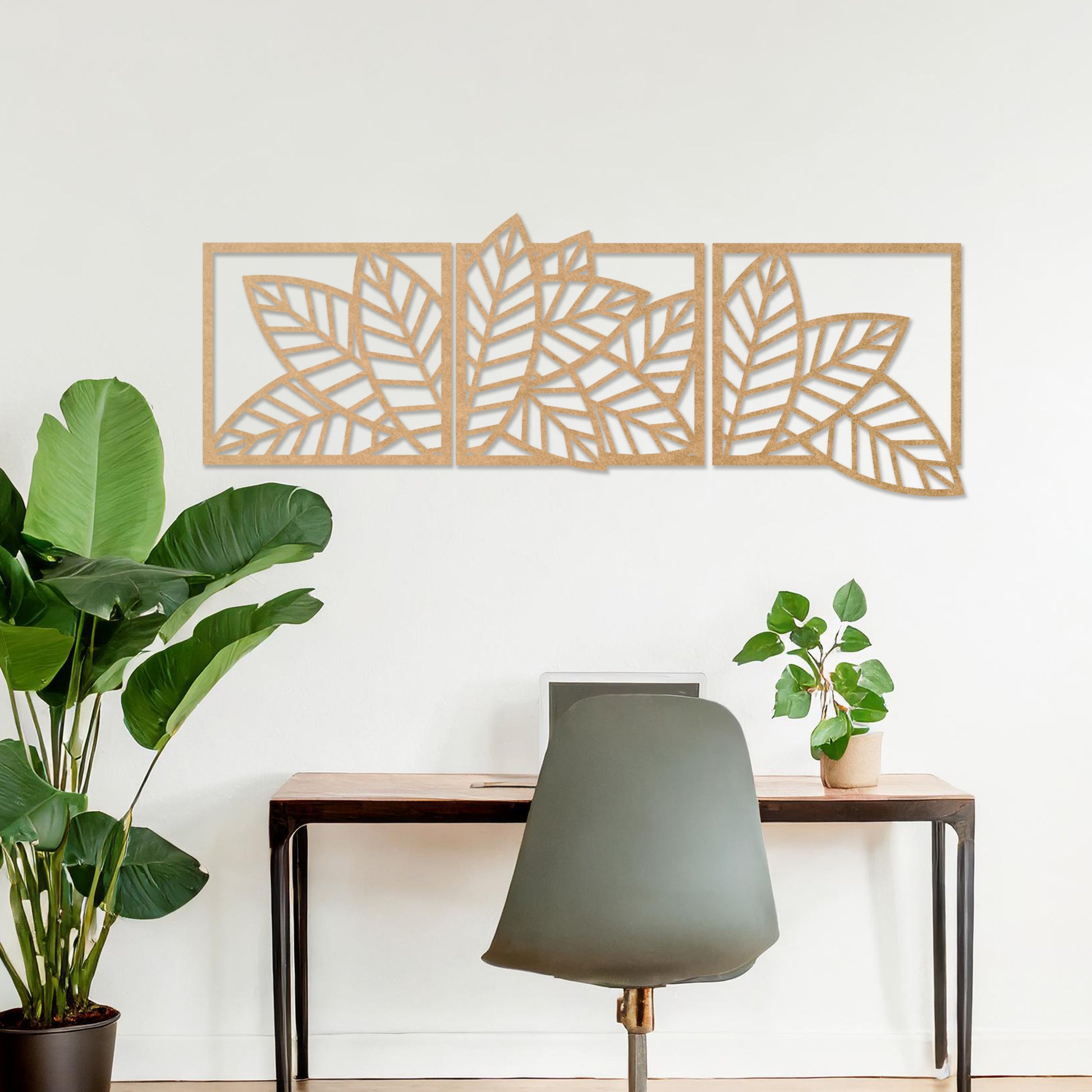 Wooden wall art featuring a three-panel design of overlapping leaf patterns with intricate cut-outs. The artwork is displayed on a neutral wall within modern room decor, highlighting its natural and elegant design.