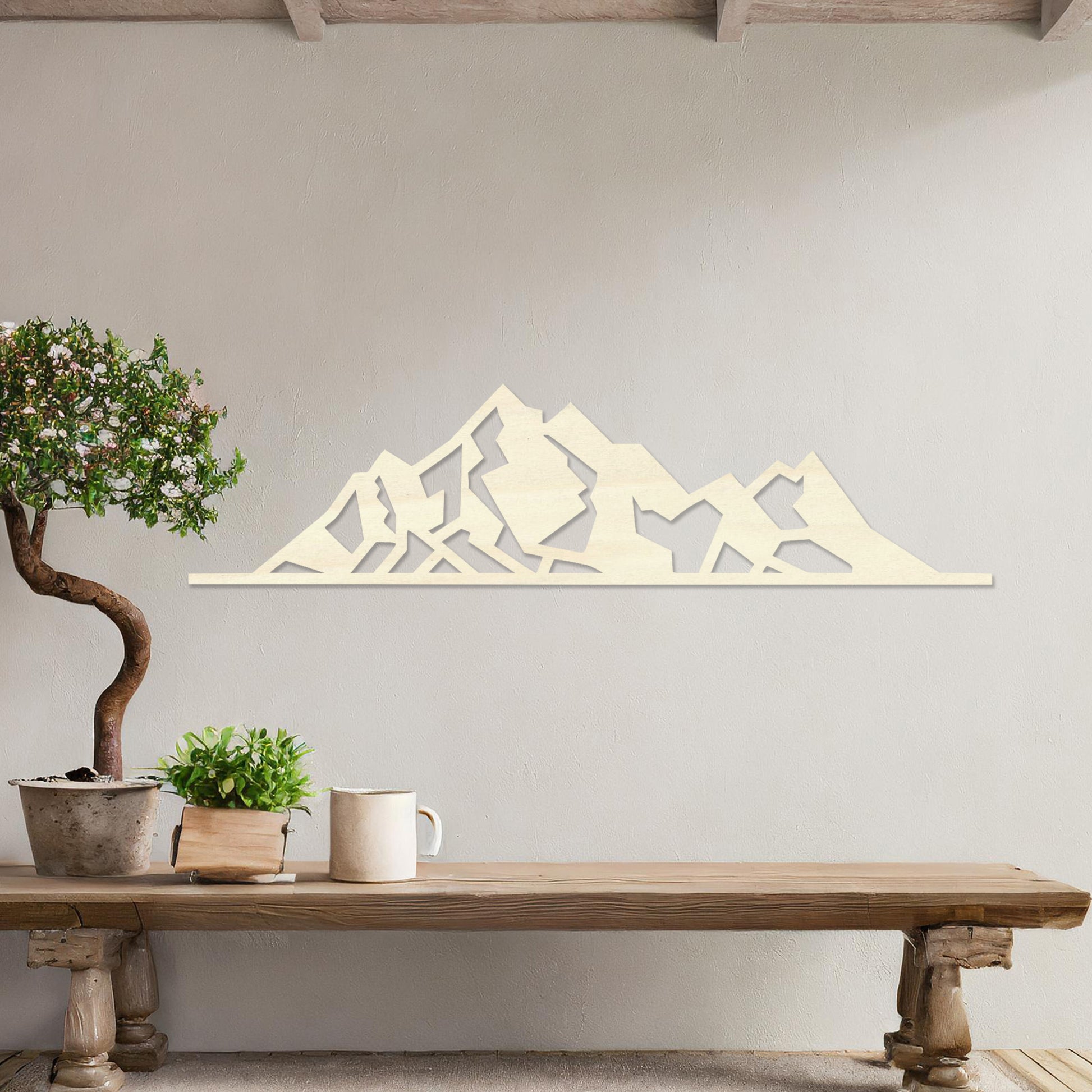Wall art featuring a minimalist mountain range design with sharp geometric peaks. The piece is displayed on a neutral wall within modern decor, adding a natural and contemporary accent to the space.