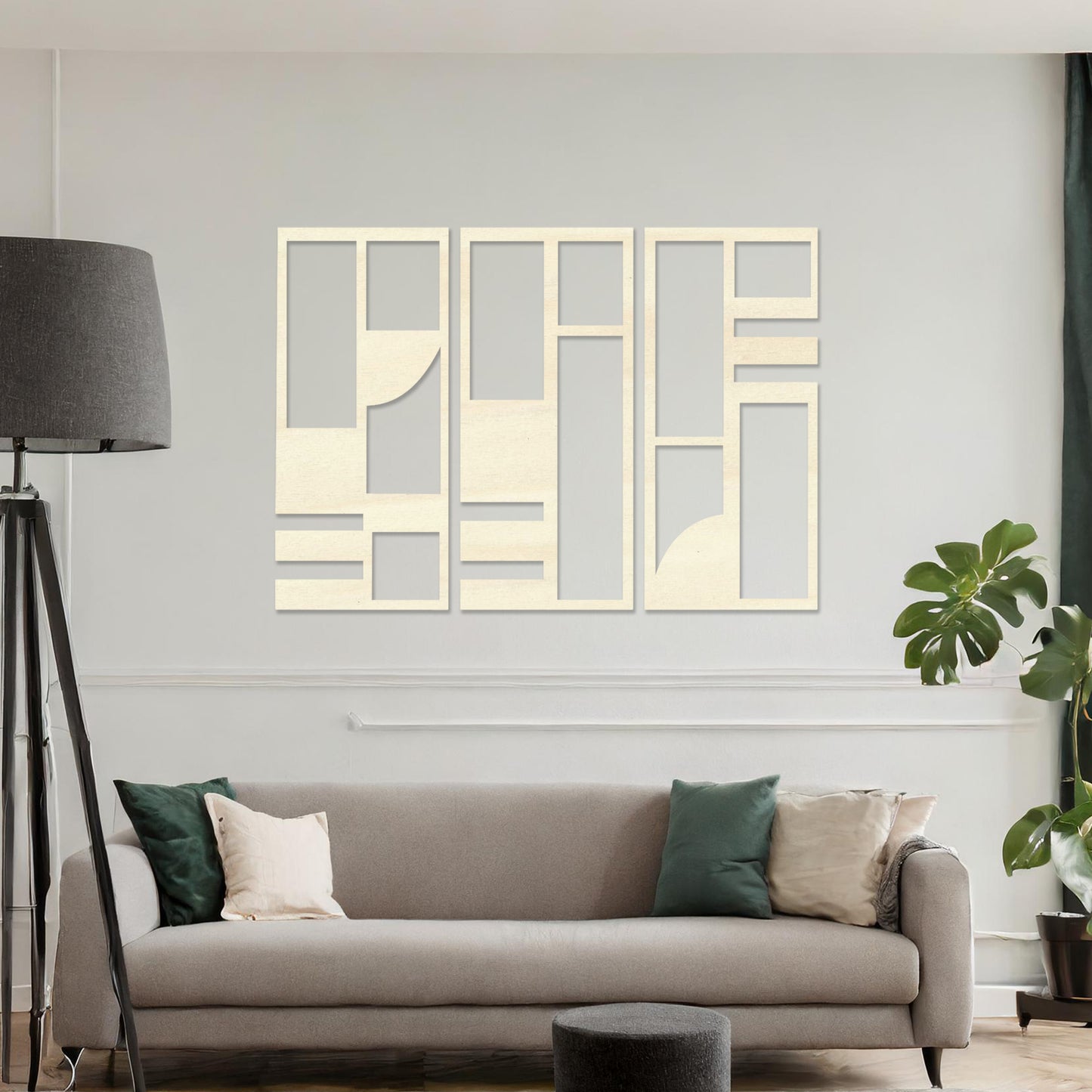 This image displays a modern, abstract triptych wall art piece featuring geometric patterns in dark tones. The artwork is placed above a simple desk setup with a plant and a chair, providing a stylish and minimalistic atmosphere suitable for a contemporary workspace. 
