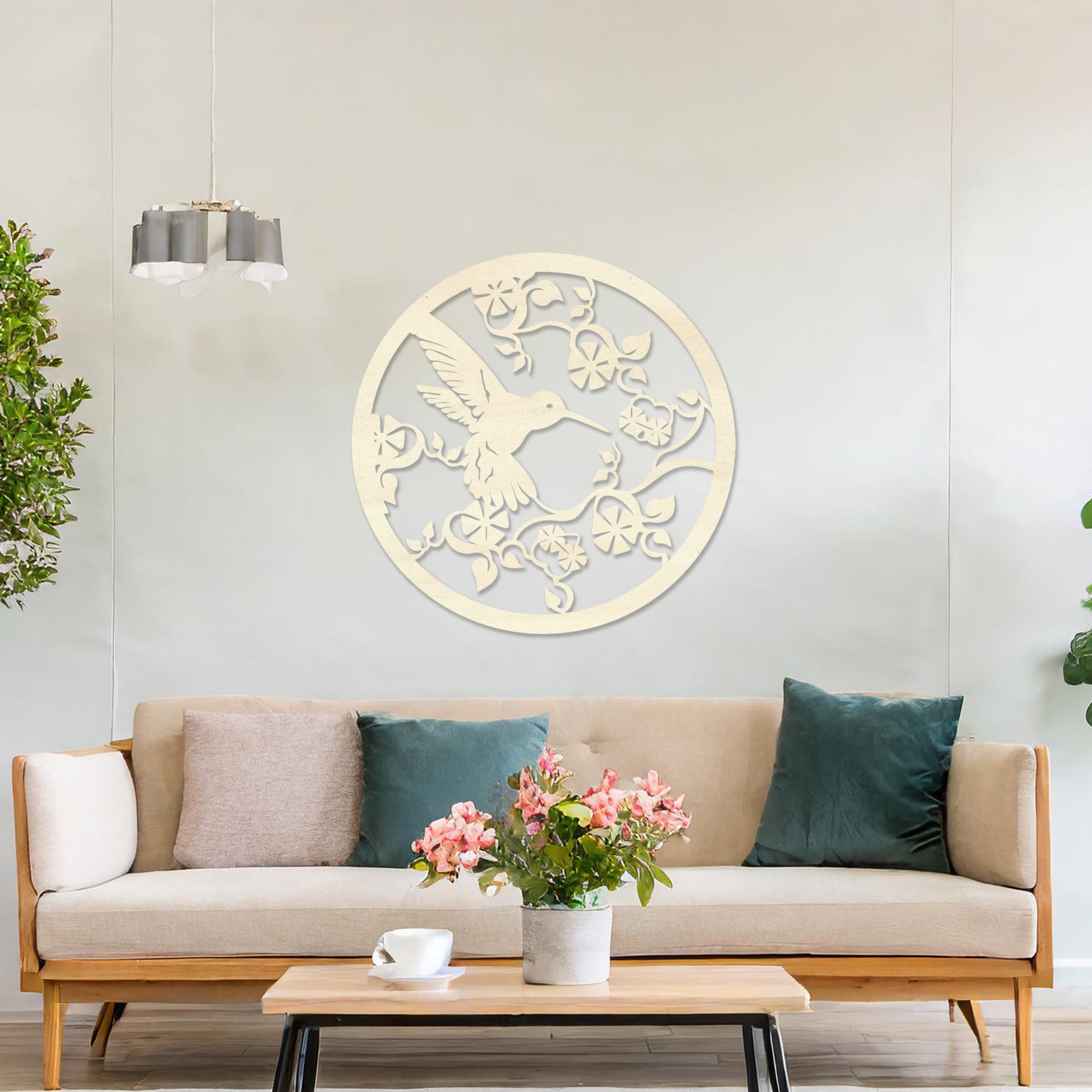 Wooden wall art design featuring a hummingbird amidst flowers and vines, framed in a circular shape, placed on a neutral wall within modern room decor. The design captures the elegance of nature with intricate details.