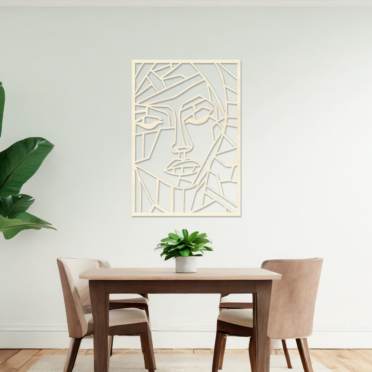 A rectangular wall art piece featuring an abstract face design composed of geometric shapes and clean lines. The artwork is displayed on a neutral wall in a contemporary living room, 