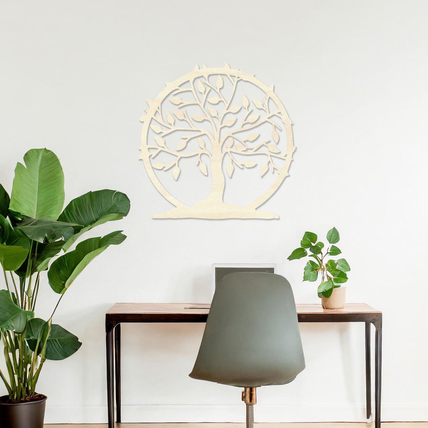 Wooden wall art featuring a circular tree design with branches, leaves, and a border of thorns. The artwork is displayed on a neutral wall within modern room decor, emphasising its natural and symbolic charm.