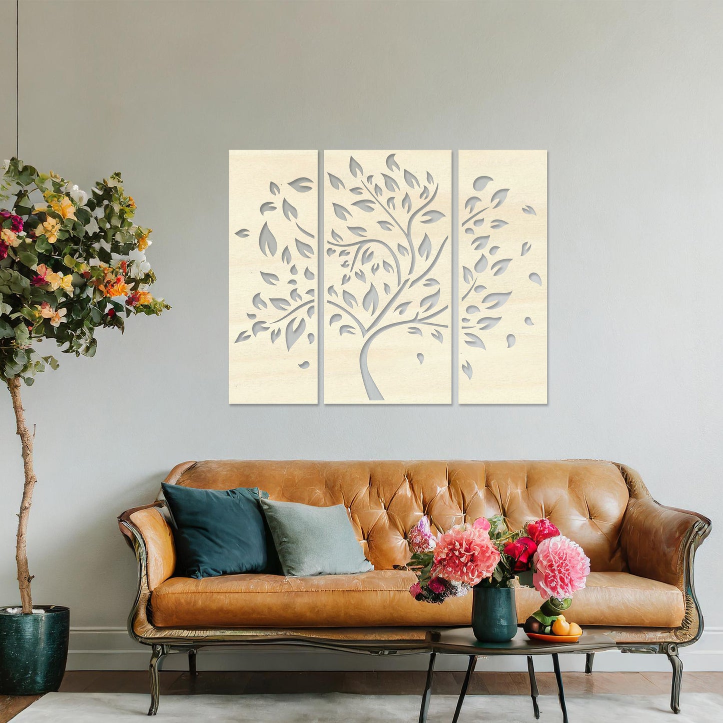 Wooden wall art consisting of three panels featuring a flowing tree design with scattered leaves, displayed on a neutral wall within modern room decor, emphasising its elegant and natural aesthetic.