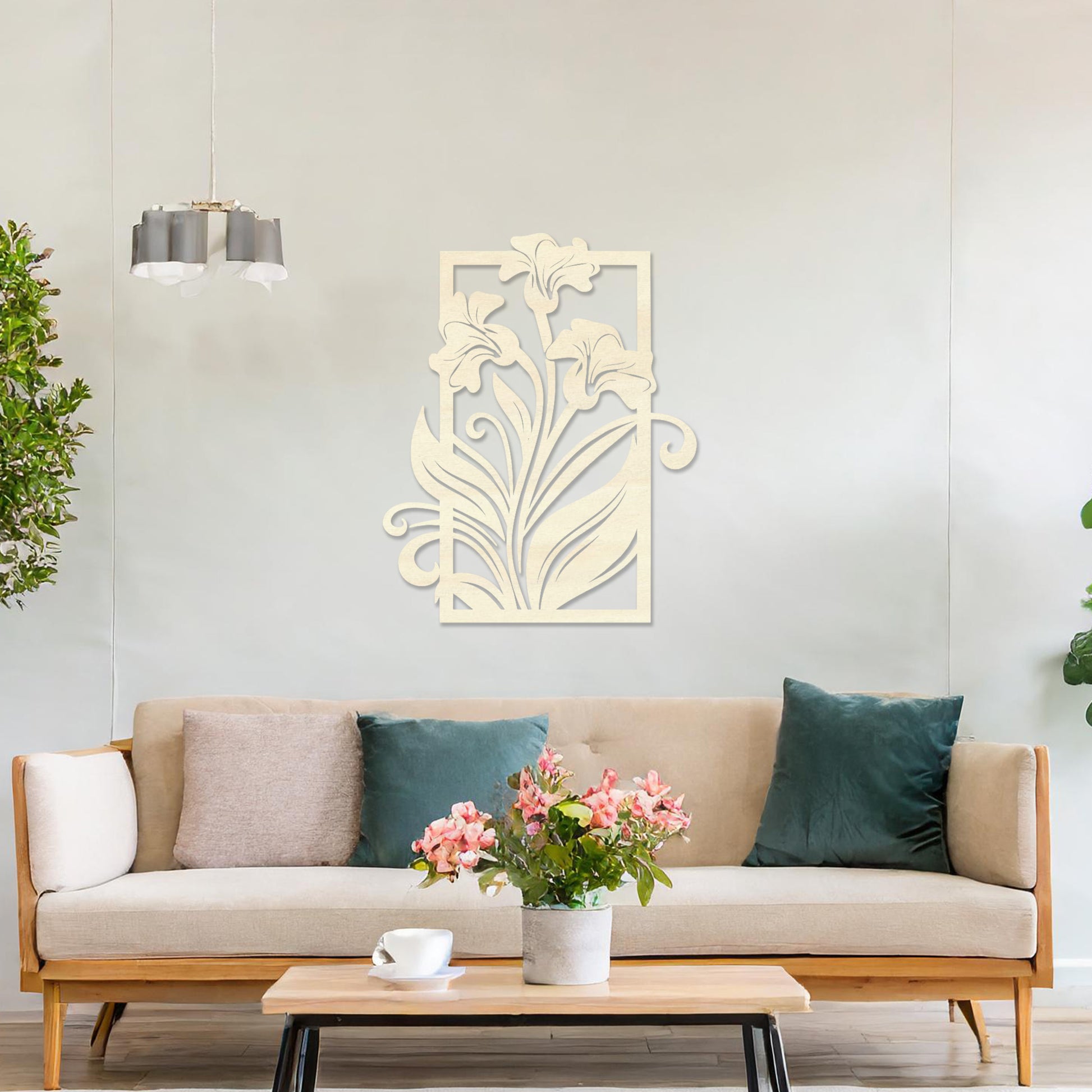 Wall art featuring an elegant floral design with three blooming lilies and flowing leaves enclosed in a rectangular frame. The piece is displayed on a neutral wall within modern room decor, adding a graceful and artistic touch to the setting.