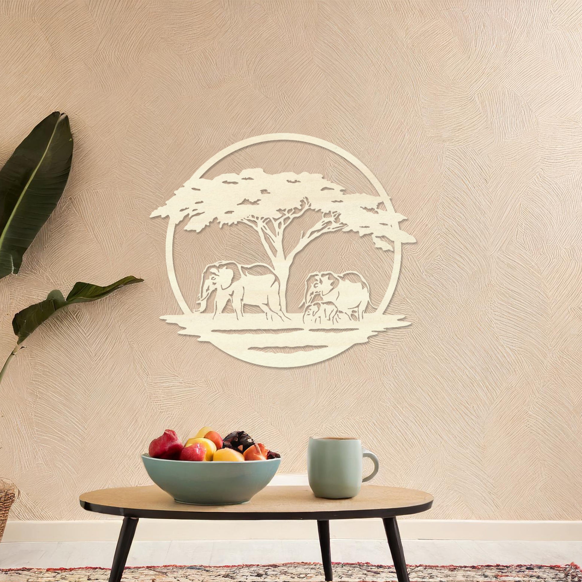 Wooden wall art design featuring two elephants under a tree, framed in a circular shape, placed on a neutral wall within modern room decor. The design evokes a sense of tranquility and nature with its detailed depiction of wildlife.