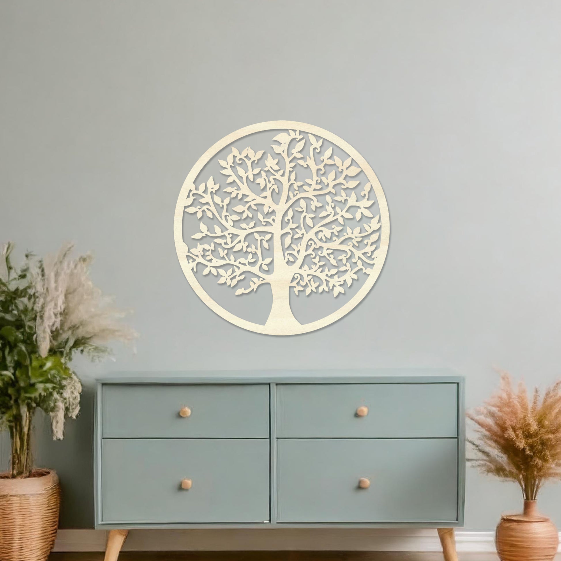 Wooden wall art featuring a circular design with an intricately detailed tree of life motif. The artwork is displayed on a neutral wall within modern room decor, highlighting its symbolic and artistic appeal.