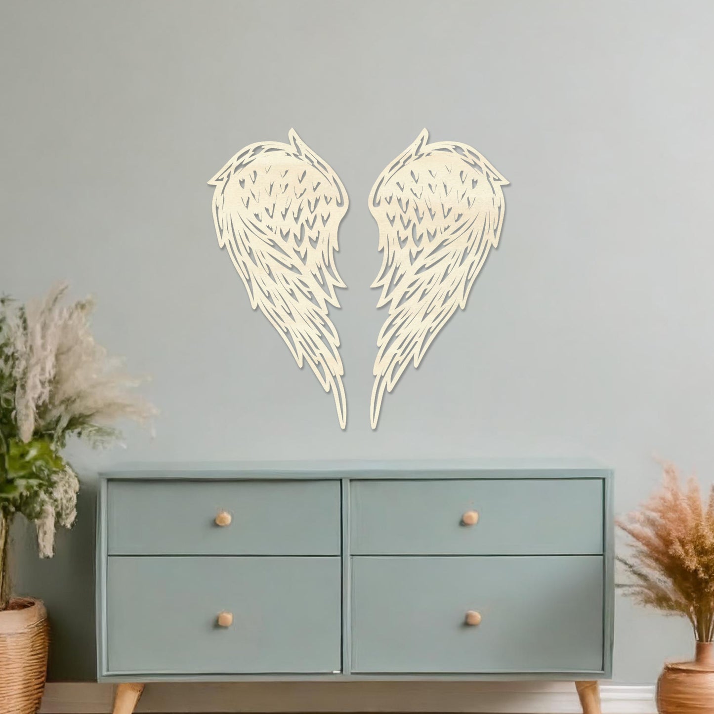 Wall art showcasing intricately designed angel wings with detailed feather patterns, displayed on a neutral wall in a modern living room. The piece adds a sense of elegance and serenity to the contemporary decor.