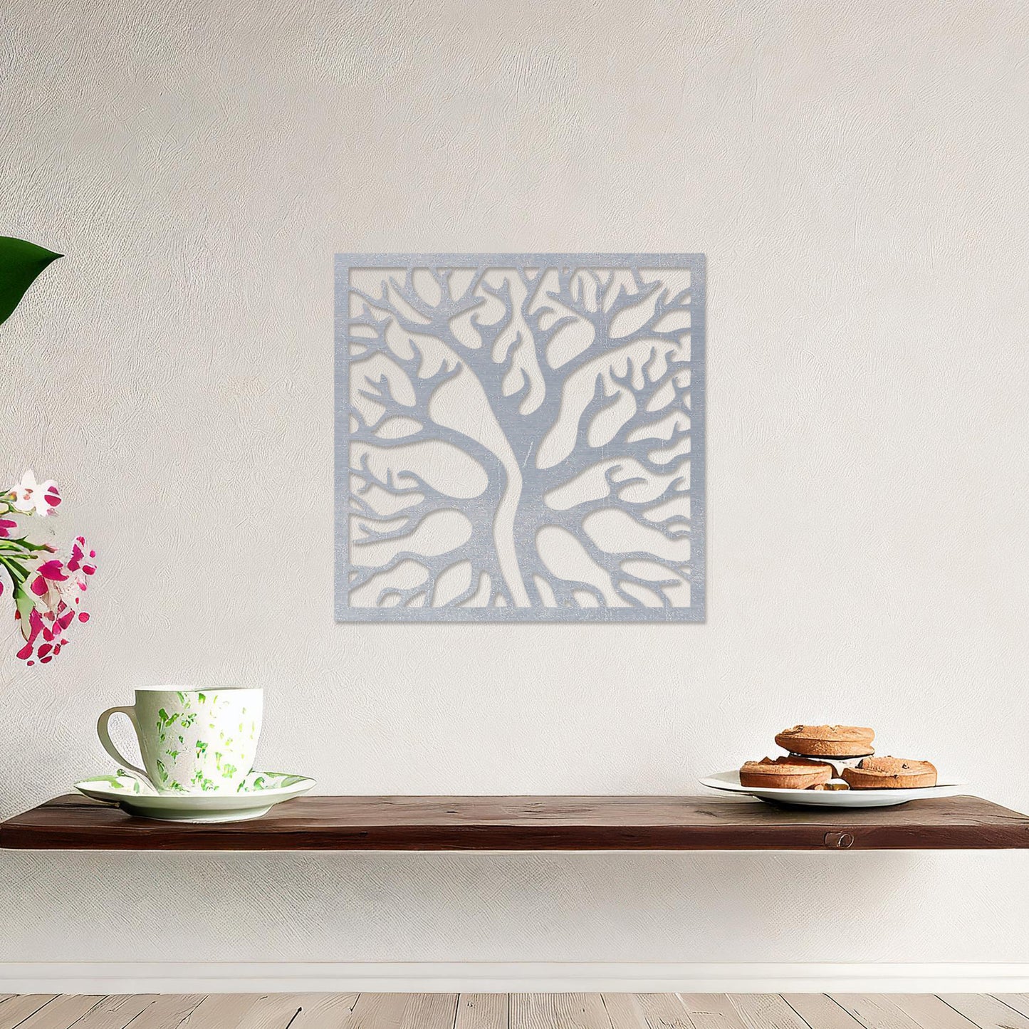 Square wall art featuring a stylised tree with intertwining branches, showcasing a modern and organic design. The artwork is displayed on a neutral wall in a contemporary living room with a sleek sofa and complementary decor.