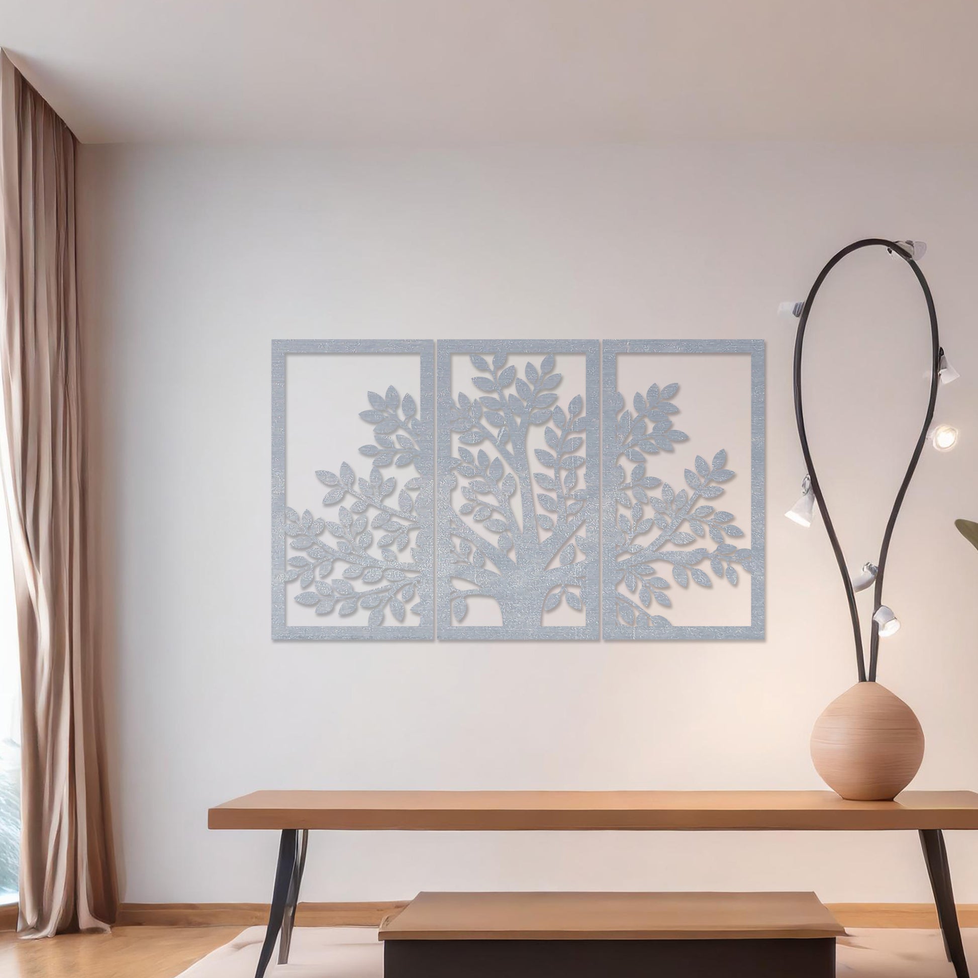 Wooden wall art comprising three panels featuring a tree design with detailed leaves and branches, displayed on a neutral wall within modern room decor, showcasing its intricate and natural craftsmanship.