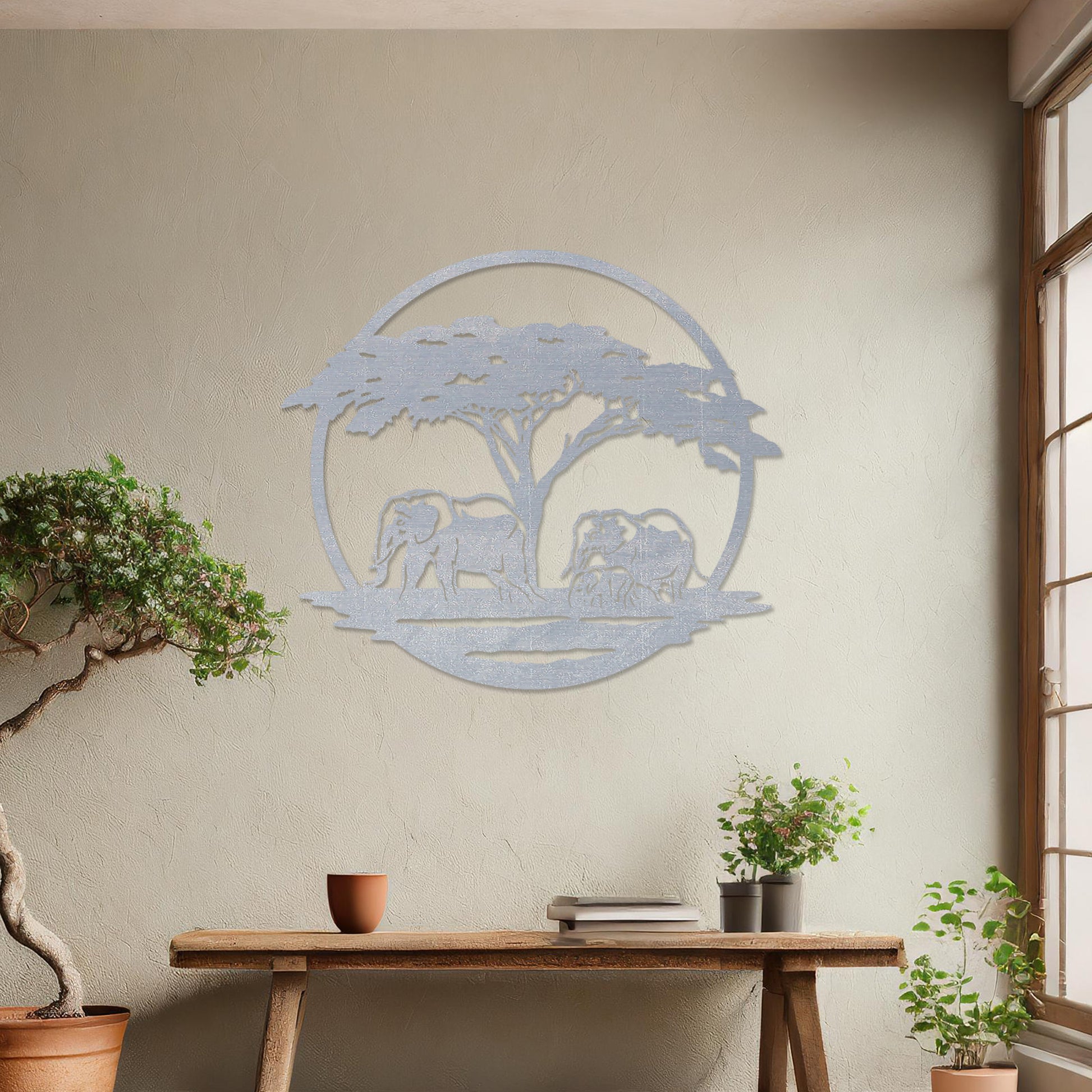 Wooden wall art design featuring two elephants under a tree, framed in a circular shape, placed on a neutral wall within modern room decor. The design evokes a sense of tranquility and nature with its detailed depiction of wildlife.