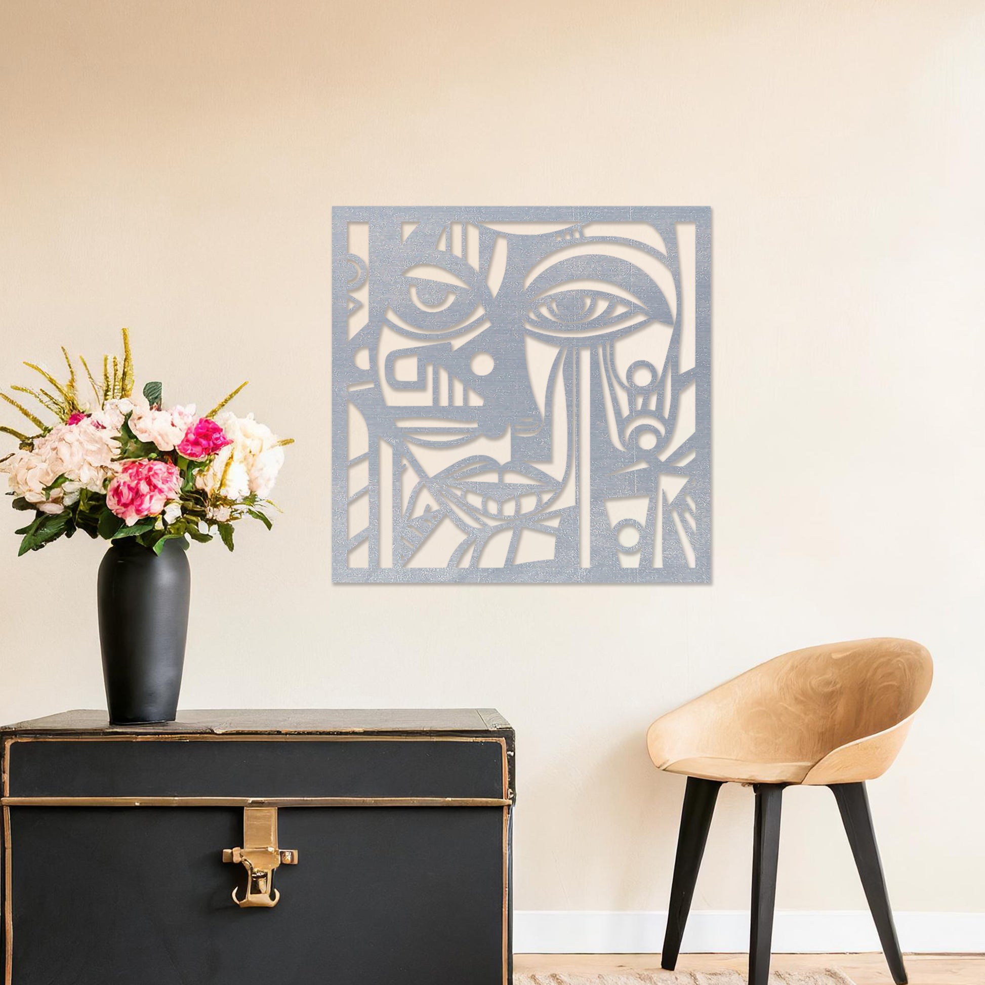 Wall art featuring an abstract face design with geometric patterns and intricate details, creating a modern and artistic composition. The piece is displayed on a neutral wall within rustic-modern decor, adding a bold and expressive focal point to the space.