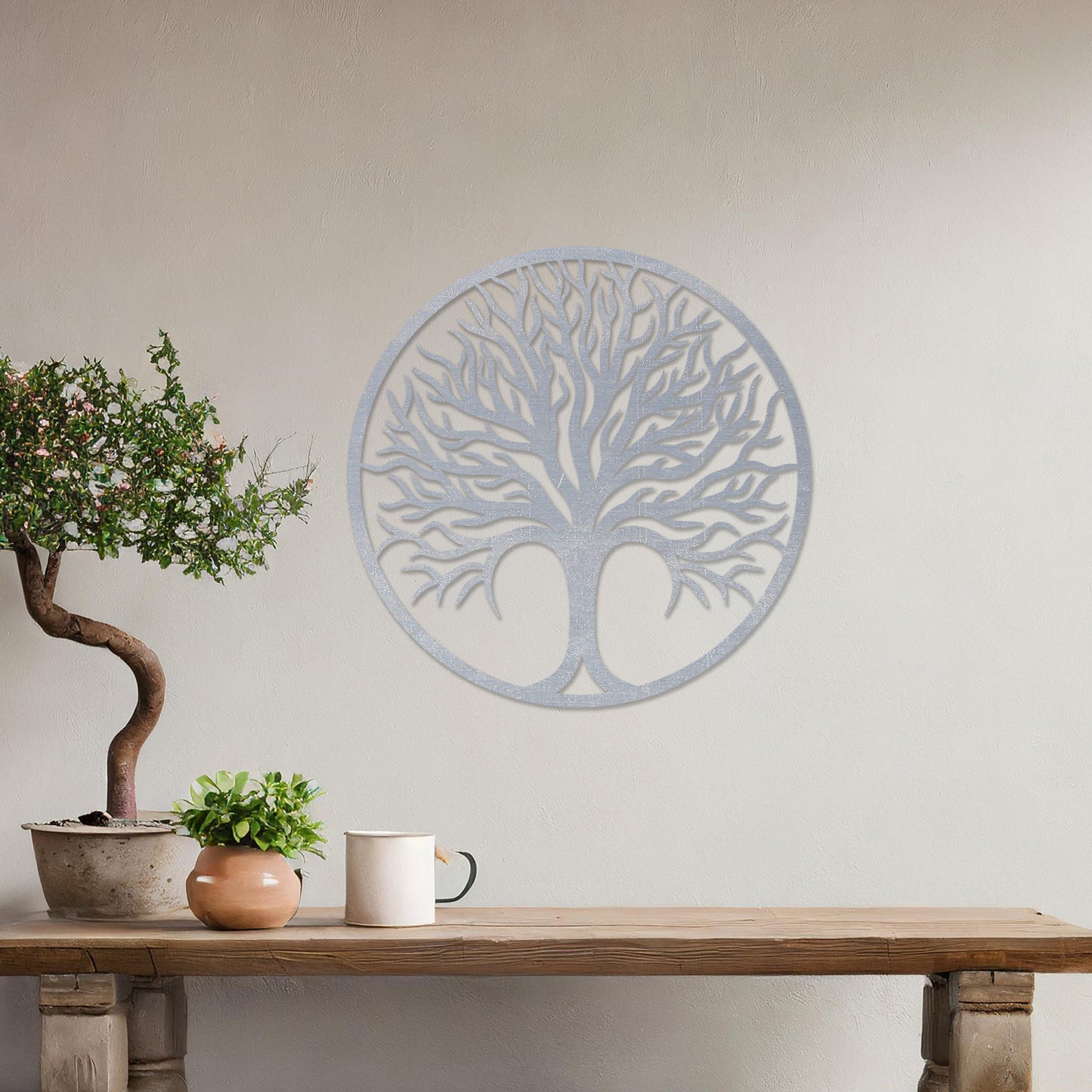 Circular wall art featuring a detailed tree design with spreading branches, symbolising life and growth. This piece is displayed on a neutral wall in a modern room, complementing the elegant and contemporary decor.