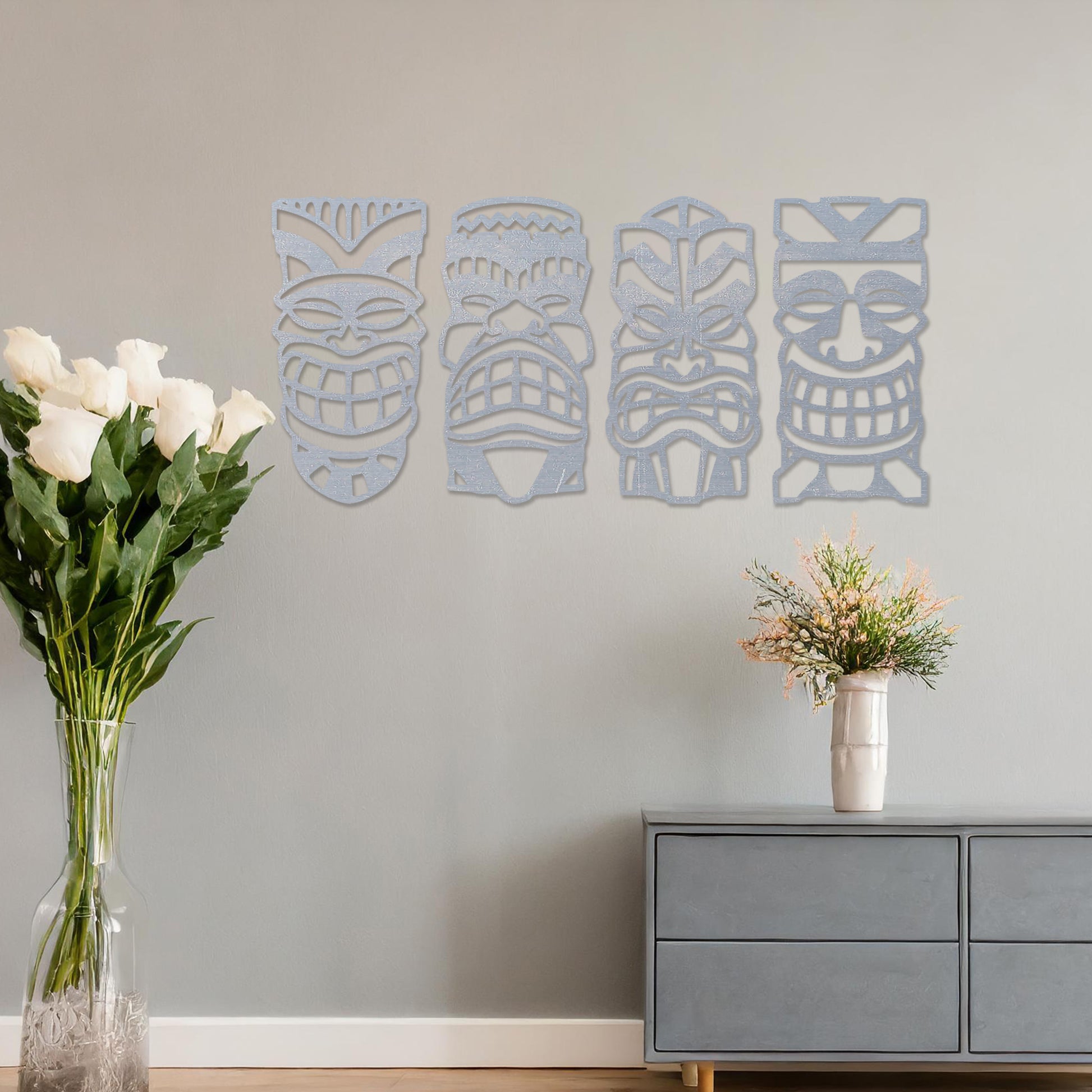 Wooden wall art design featuring four tribal masks arranged in a row on a neutral wall, set against modern room decor. The intricate design captures bold, expressive features and cultural motifs.
