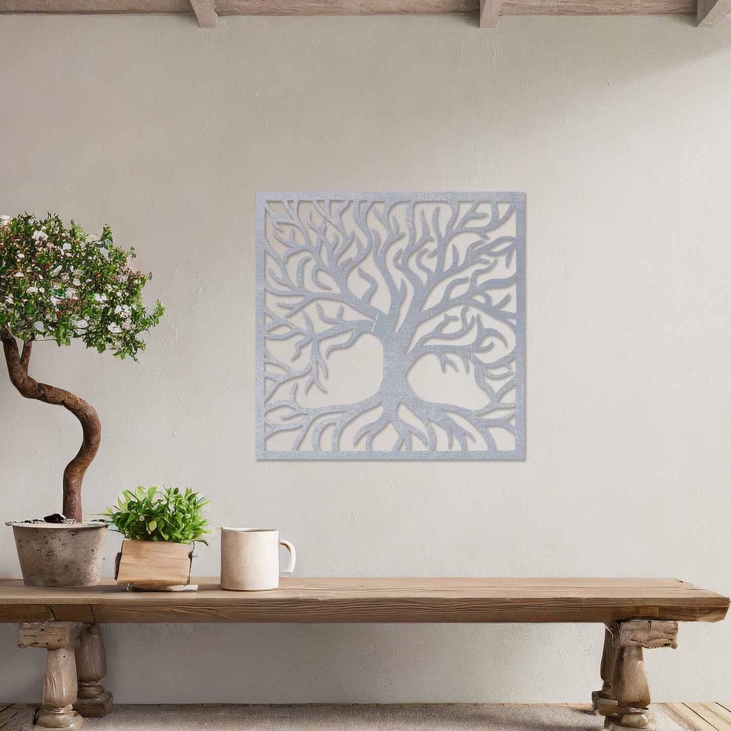A square wall art piece depicting an intricate tree with branching limbs and visible roots. The artwork is displayed on a neutral wall in a modern room