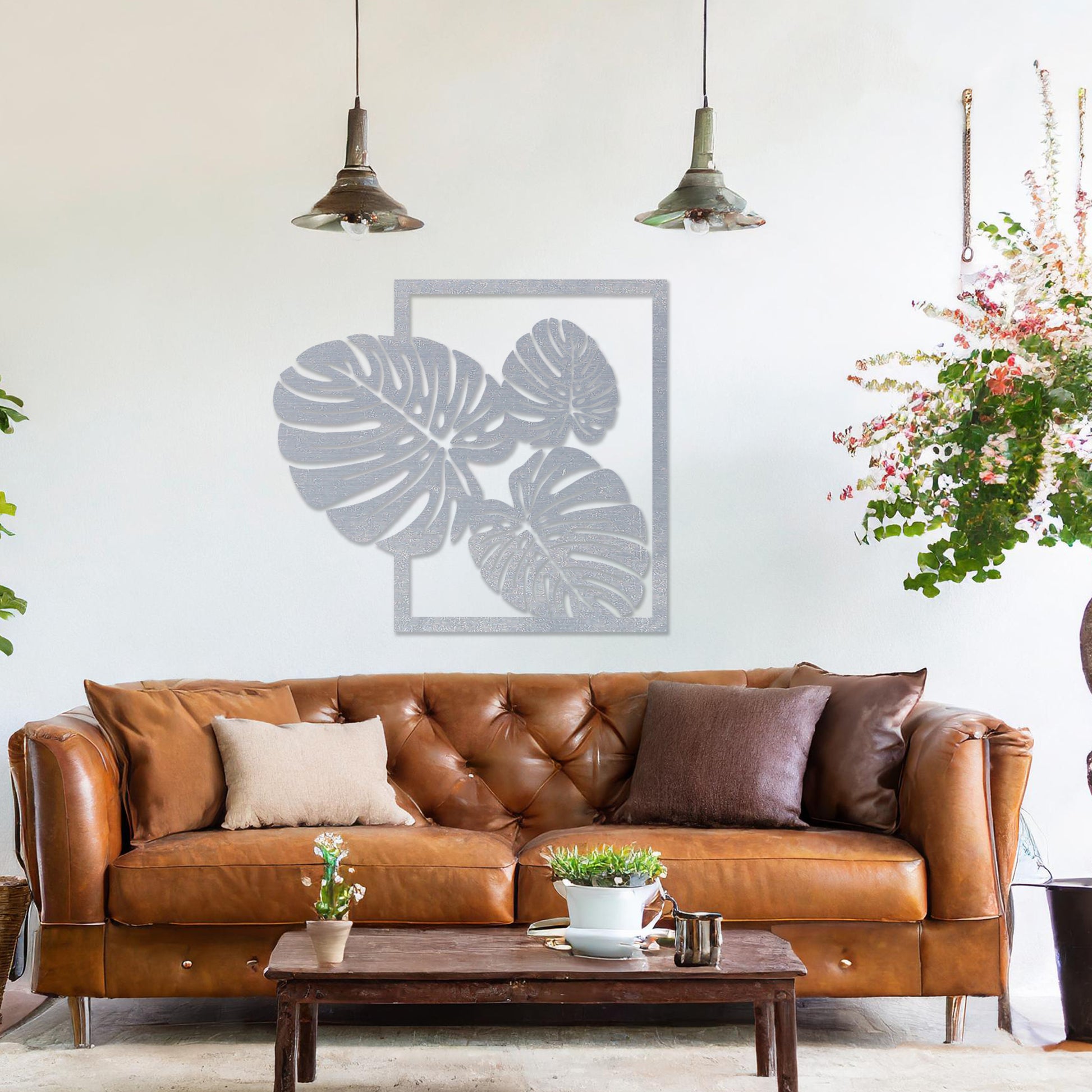 Wall art featuring a botanical design of overlapping monstera leaves framed within a rectangular border. The piece is displayed on a neutral wall within modern room decor, enhancing the natural and elegant aesthetic.