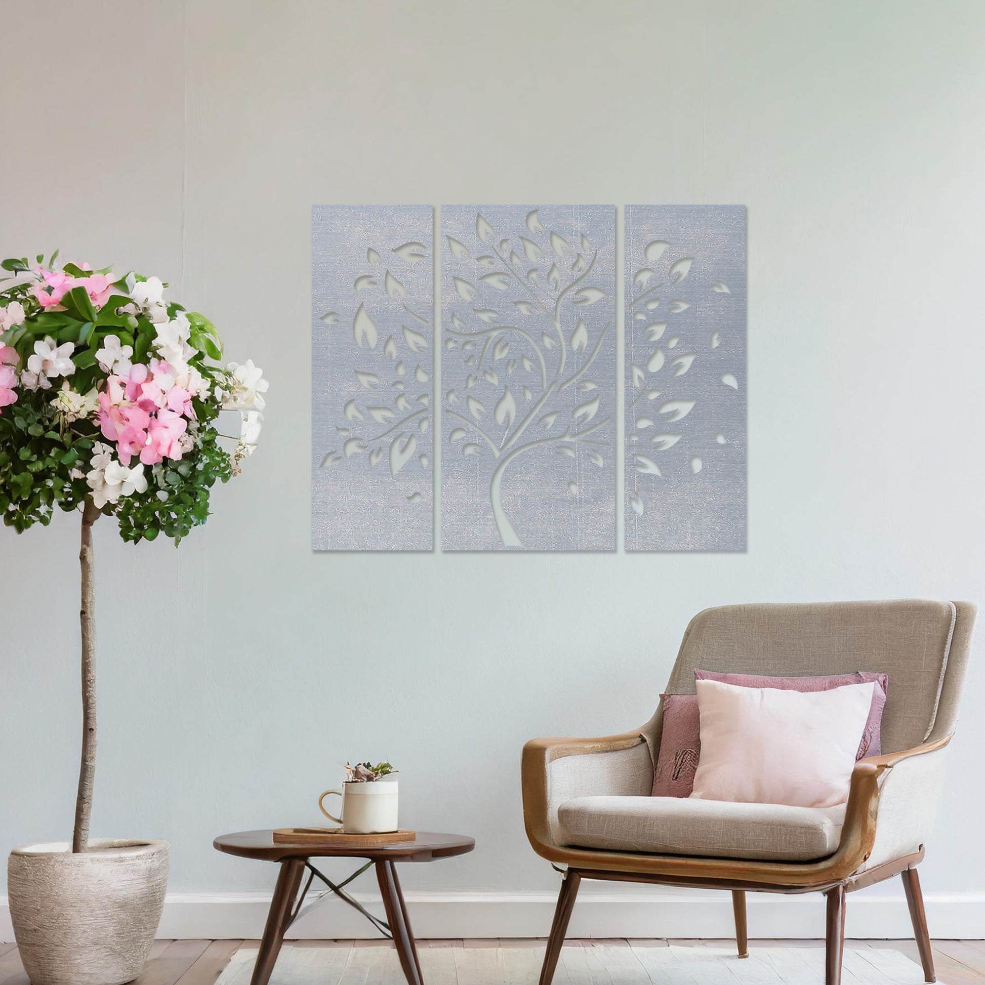 Wooden wall art consisting of three panels featuring a flowing tree design with scattered leaves, displayed on a neutral wall within modern room decor, emphasising its elegant and natural aesthetic.