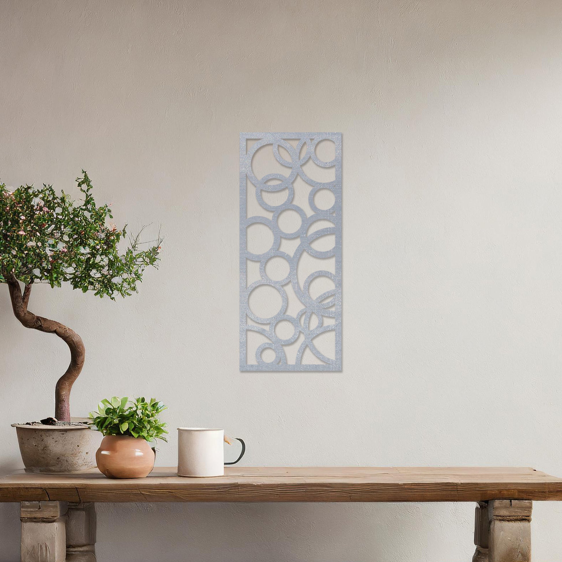 A rectangular wall art piece featuring an abstract design of overlapping circles of various sizes. The artwork is displayed on a neutral wall in a modern room,
