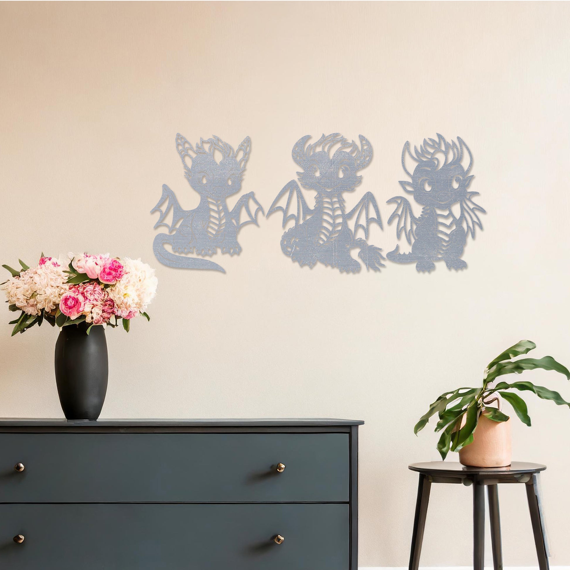 Wooden wall art design featuring three playful dragon characters, each with different poses and expressions, placed on a neutral wall within modern room decor. The design brings whimsy and charm with detailed features and lively energy.