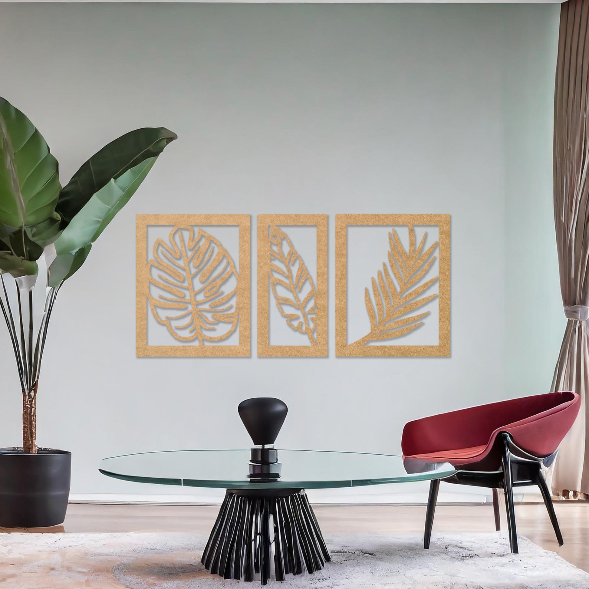 Wooden wall art set featuring three framed botanical designs with detailed leaf patterns, including monstera and palm leaves. The artwork is displayed on a neutral wall within modern room decor, adding a natural and elegant touch.